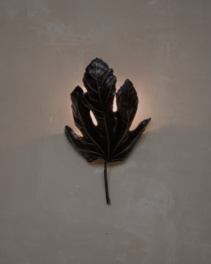Bronze fig leaf wall light with illuminated cutouts by Jess Wheeler