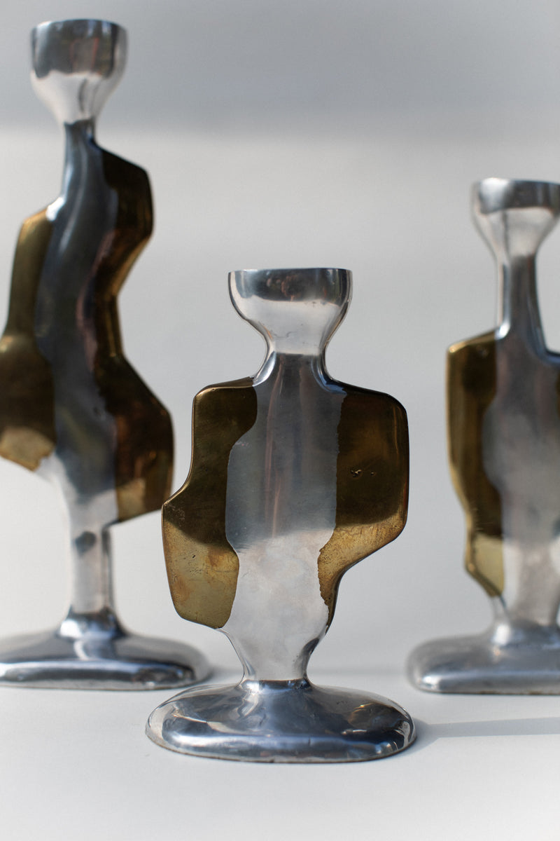 Three Brutalist Candleholders by Out For Lunch feature reflective silver and brass finishes. Their organic, sculptural forms evoke the spirit of 70s brutalist design with modern, abstract appeal.