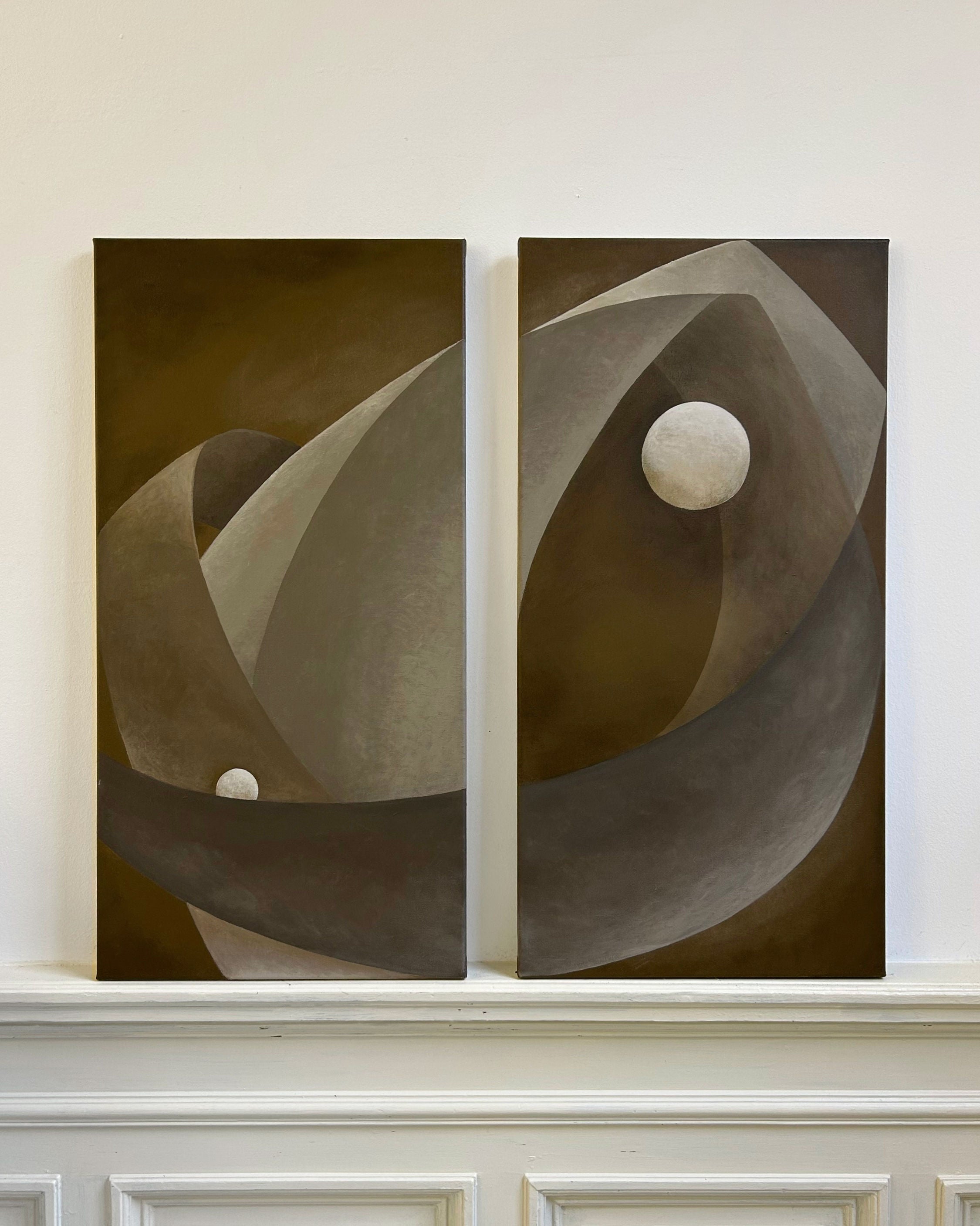 'You only live twice' paintings by Iris Bavelaar, featuring curved brown and gray shapes with white spheres on canvas and linen, are displayed side by side above a white paneled wall for a striking modern look.