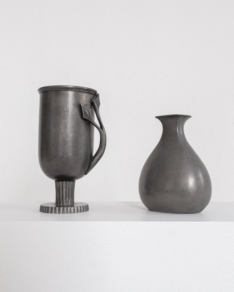 Two modernist pewter vessels: handled cup with fluted base and bulbous vase