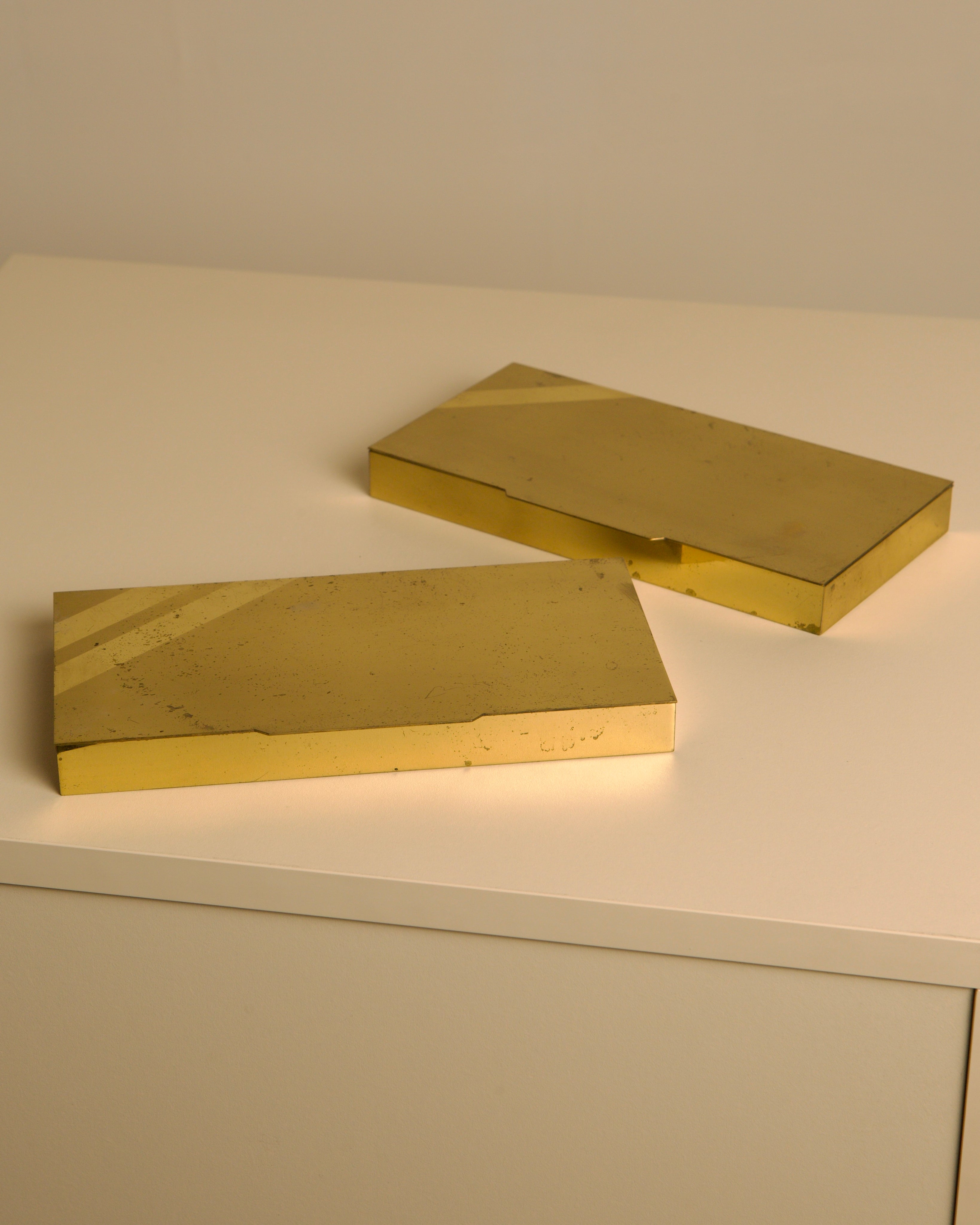 Two golden brass Italian boxes from 1960s on white surface