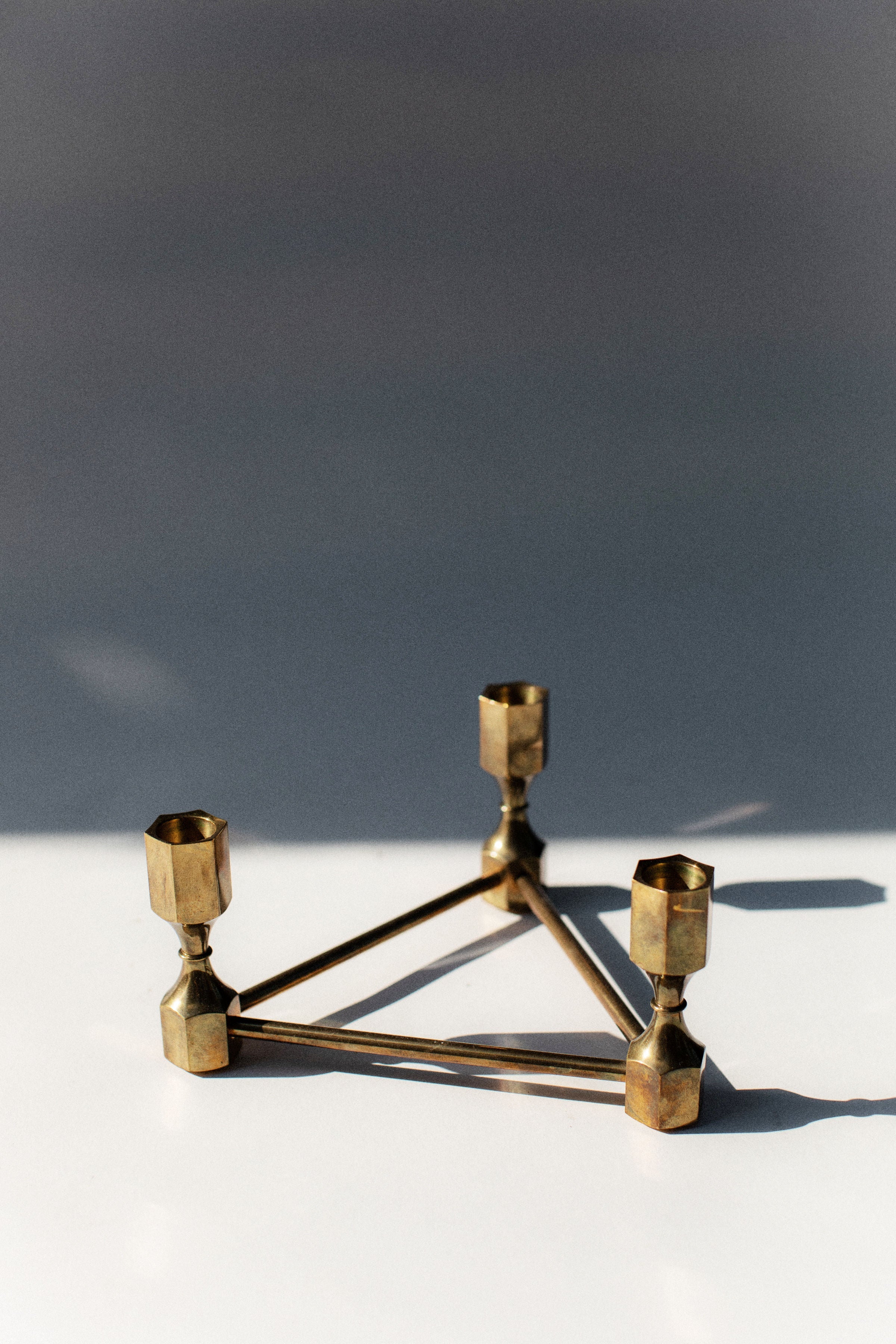 Geometric brass triangular candleholder with hexagonal candle cups