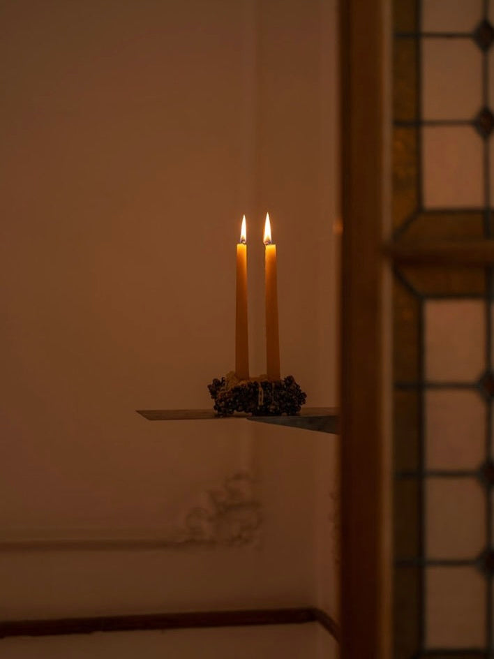 Chrome Candle Holder — candles lit on metal surface in dim setting