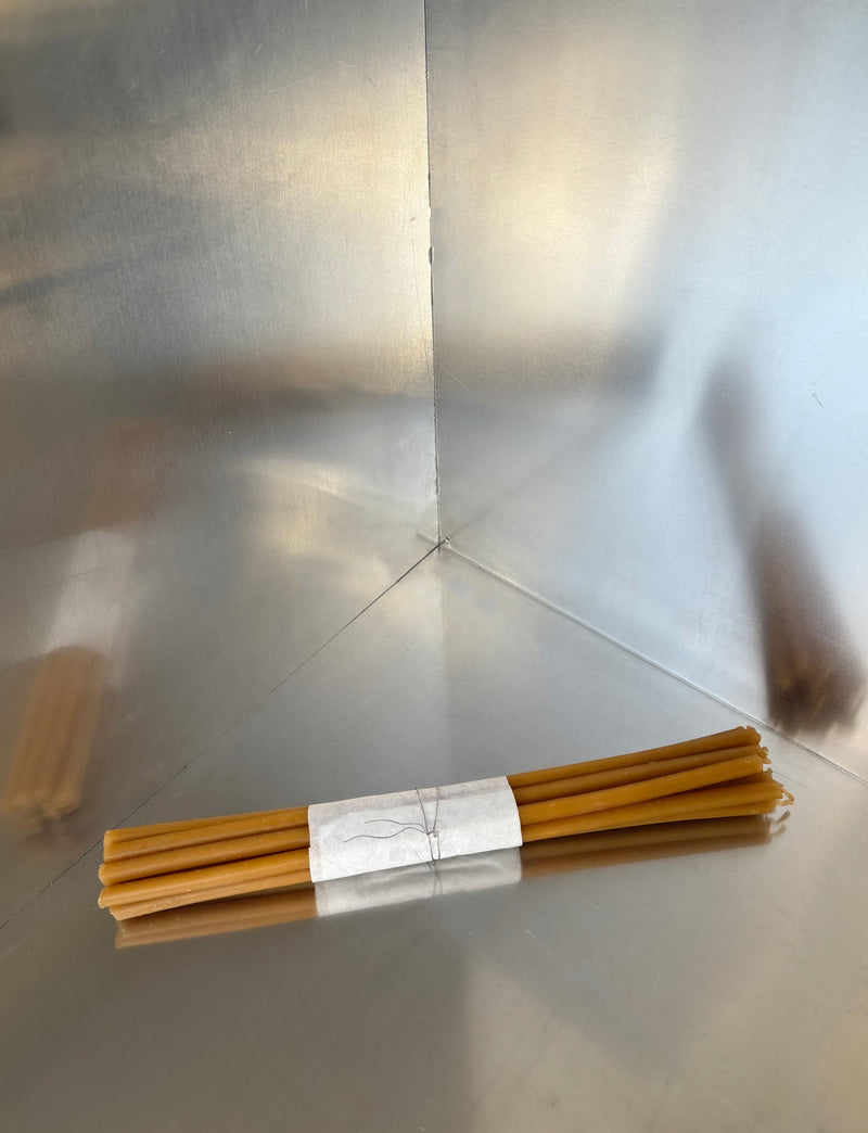 Bundle of 20 natural beeswax candles tied with white paper band