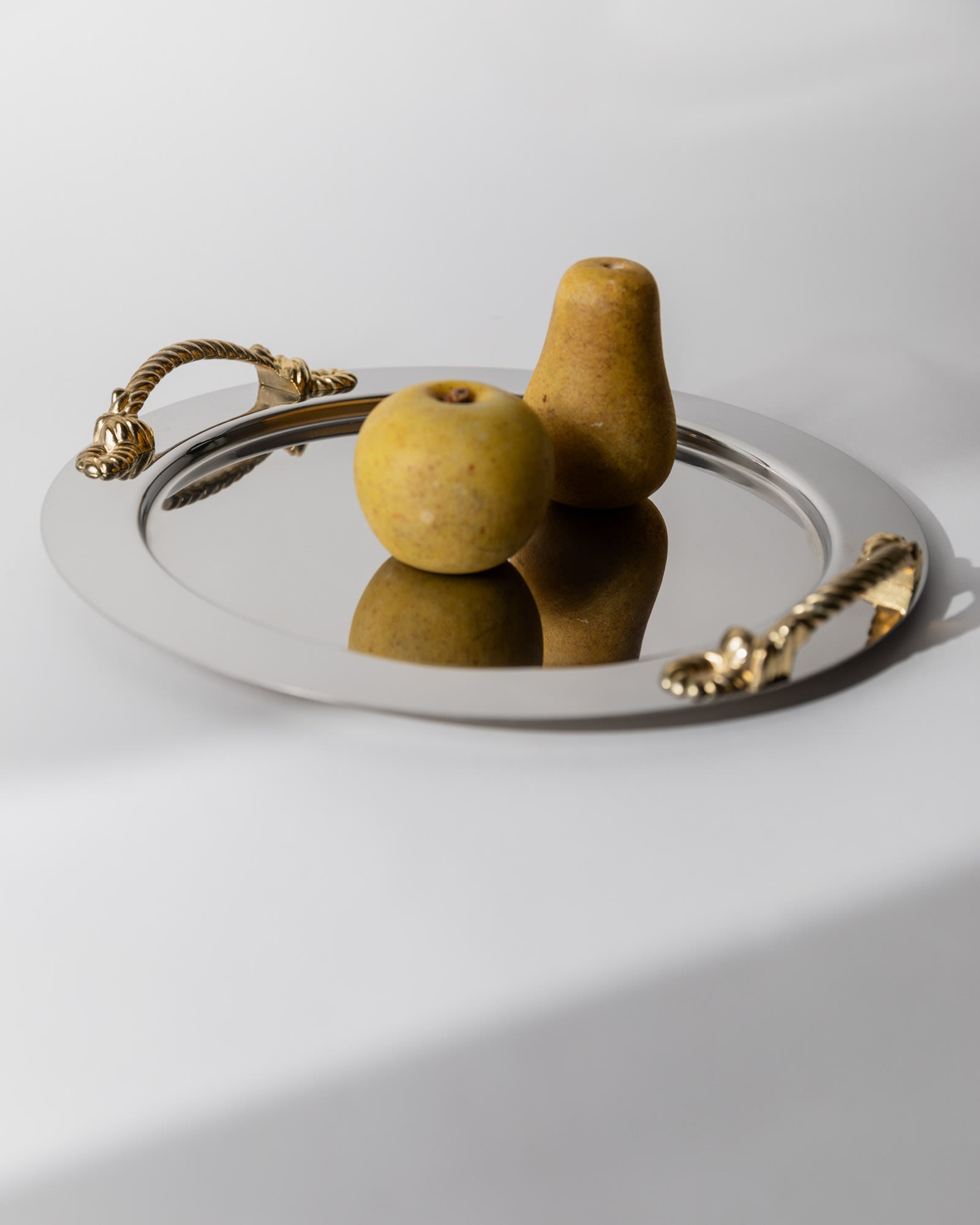 Vintage 1980s Stainless Steel Tray round, Gold Rope Handles by Inoxpran Italy — angled view with decorative fruit on tray