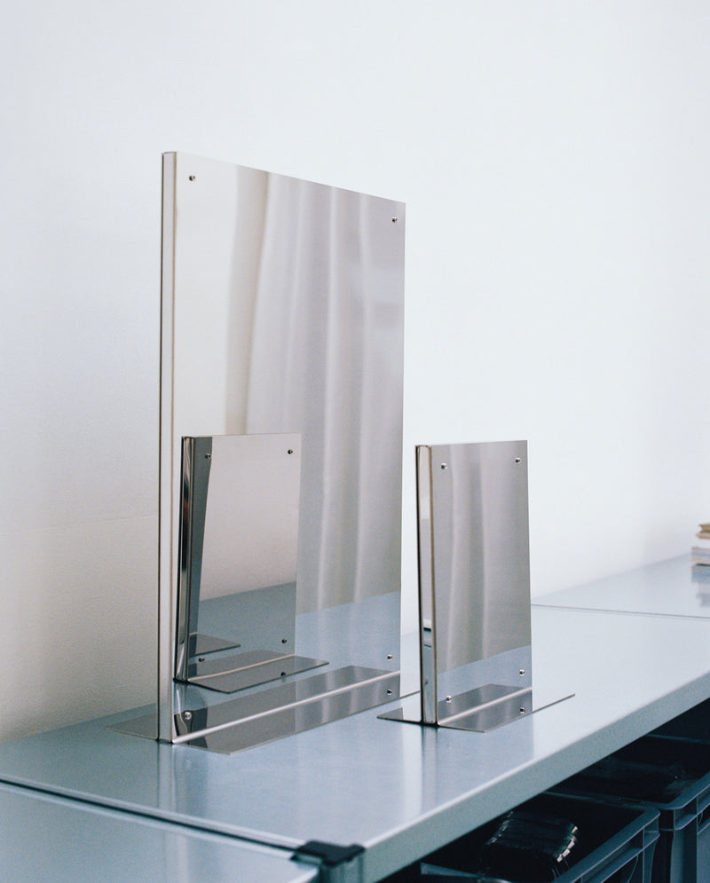 Contemporary acrylic mirror with transparent base on glass surface