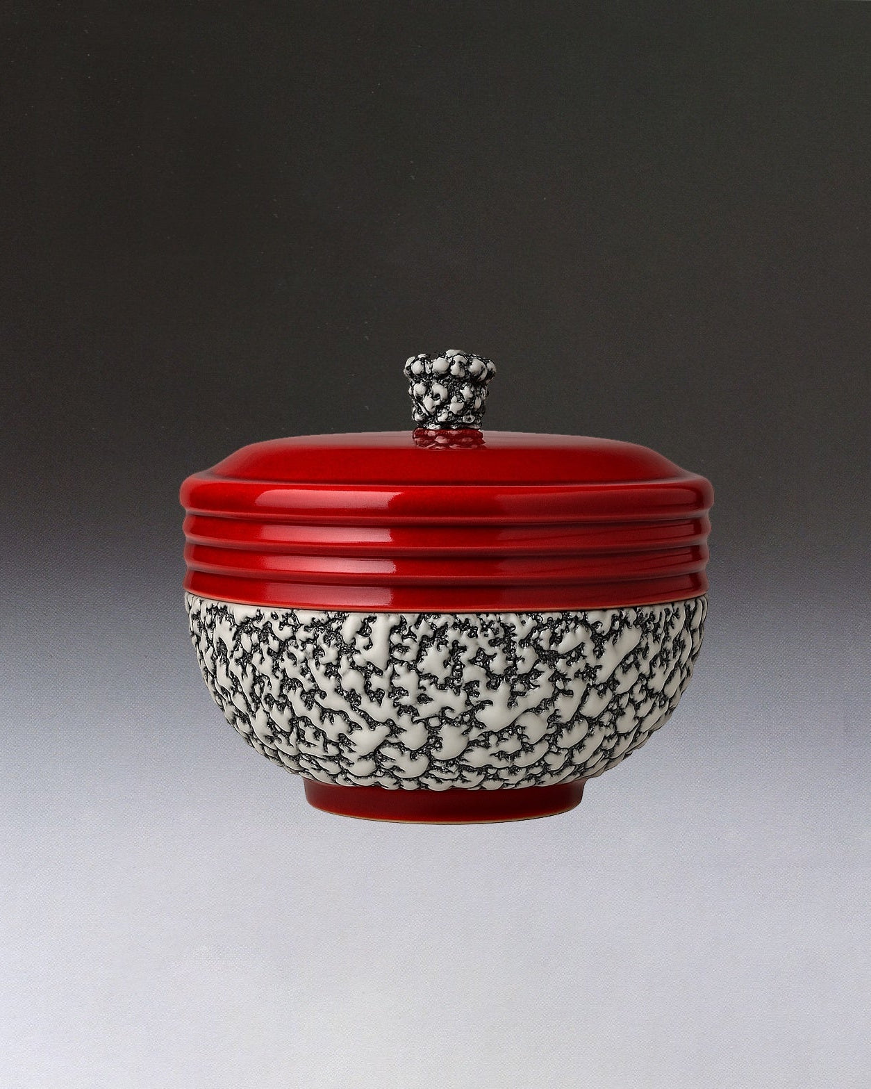 The Art Deco Ceramic Oxblood Box by Paul Millet Manufacture de Sevres from STUDIO ASAC features a white base with black branch-like patterns, a glossy red lid with knob handle, and a subtle Sevres-style gradient background.