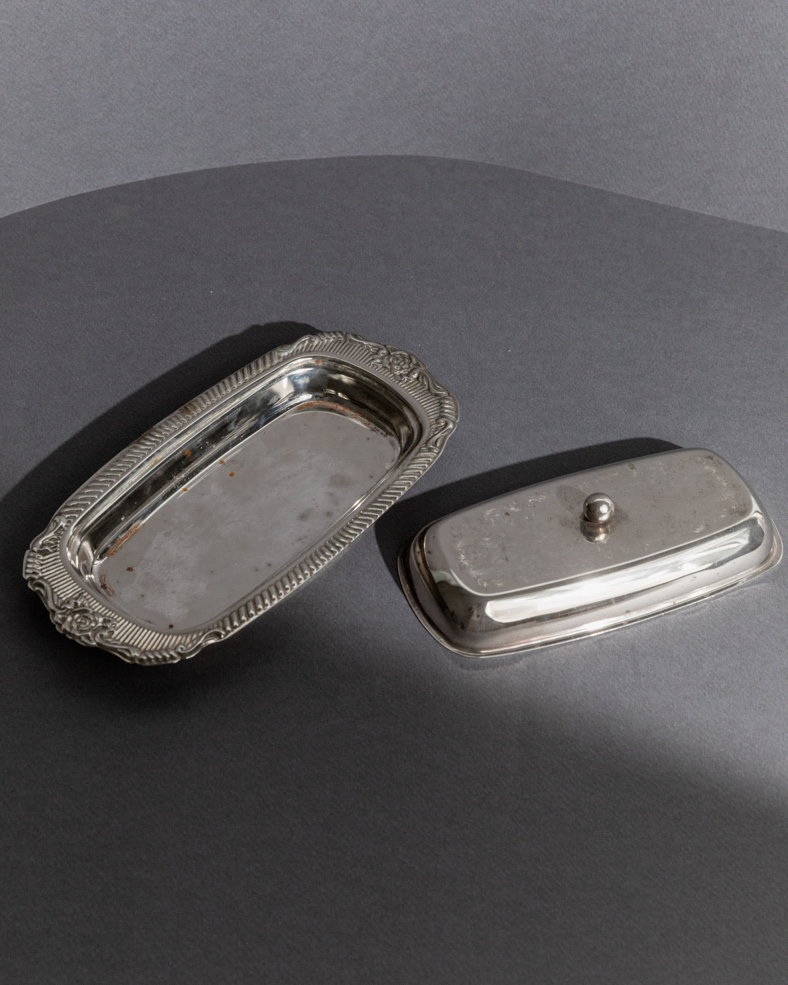 Previous slide Next slide Vintage 1970s Silver Plated Butter Dish, Engraved Ornamental — angled view on gray backdrop