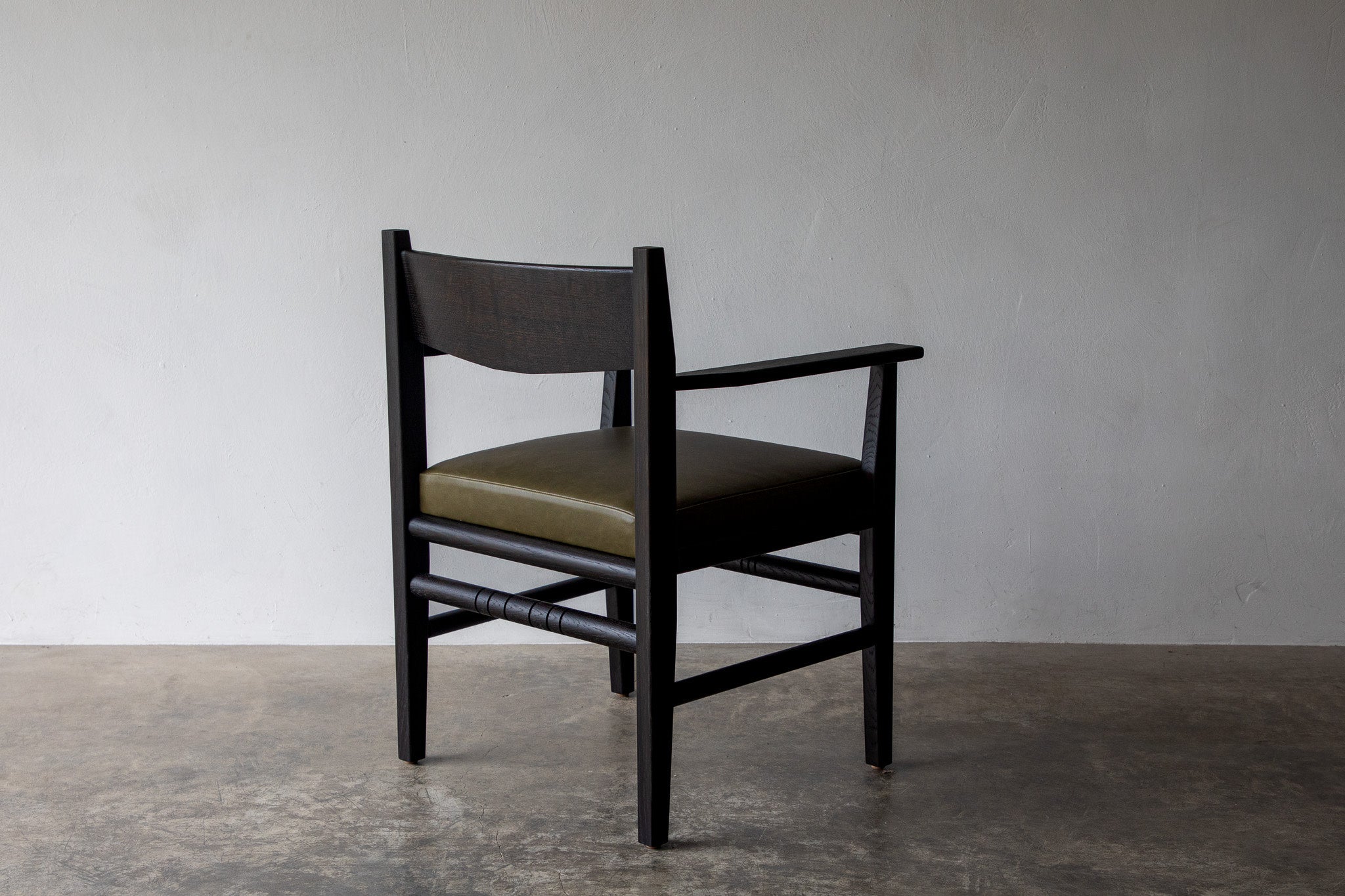 Silo Upholstered Chair — side angle with olive green seat and wooden frame