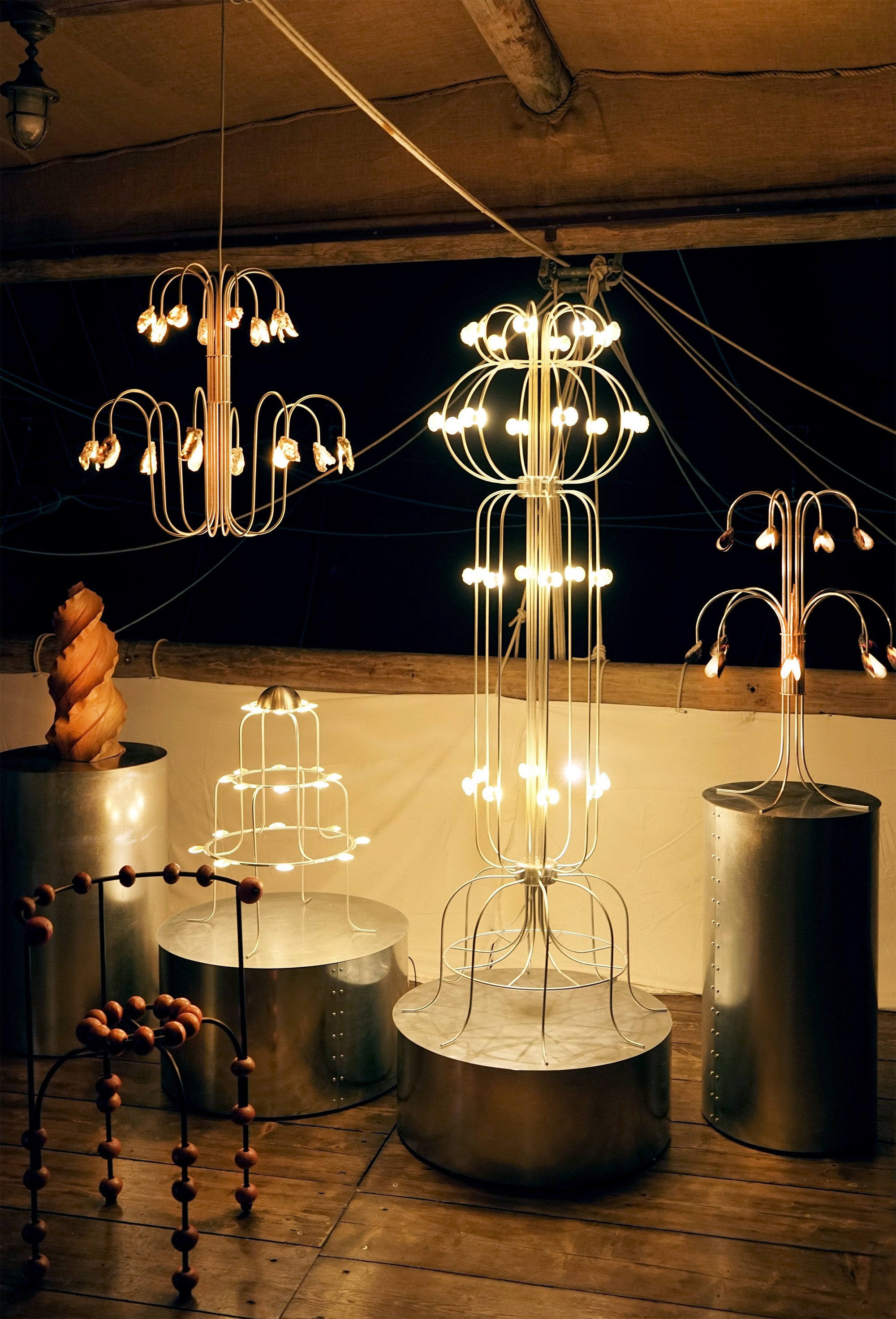 The Lamp With Shells — illuminated metal structure in dark setting