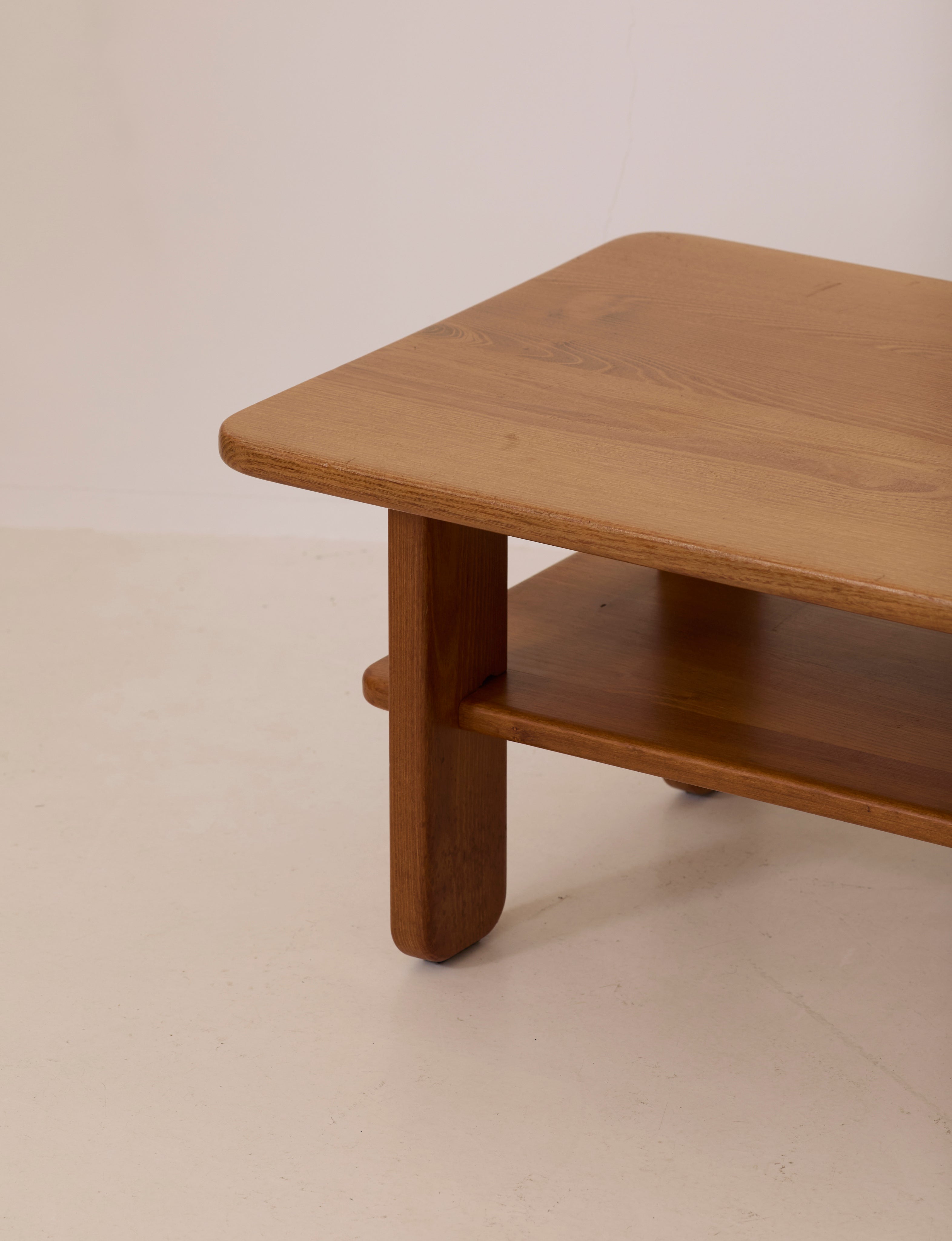 Solid elm coffee table by Alain Gaubert, France circa 1980 — side angle showing smooth wooden surface and shelf
