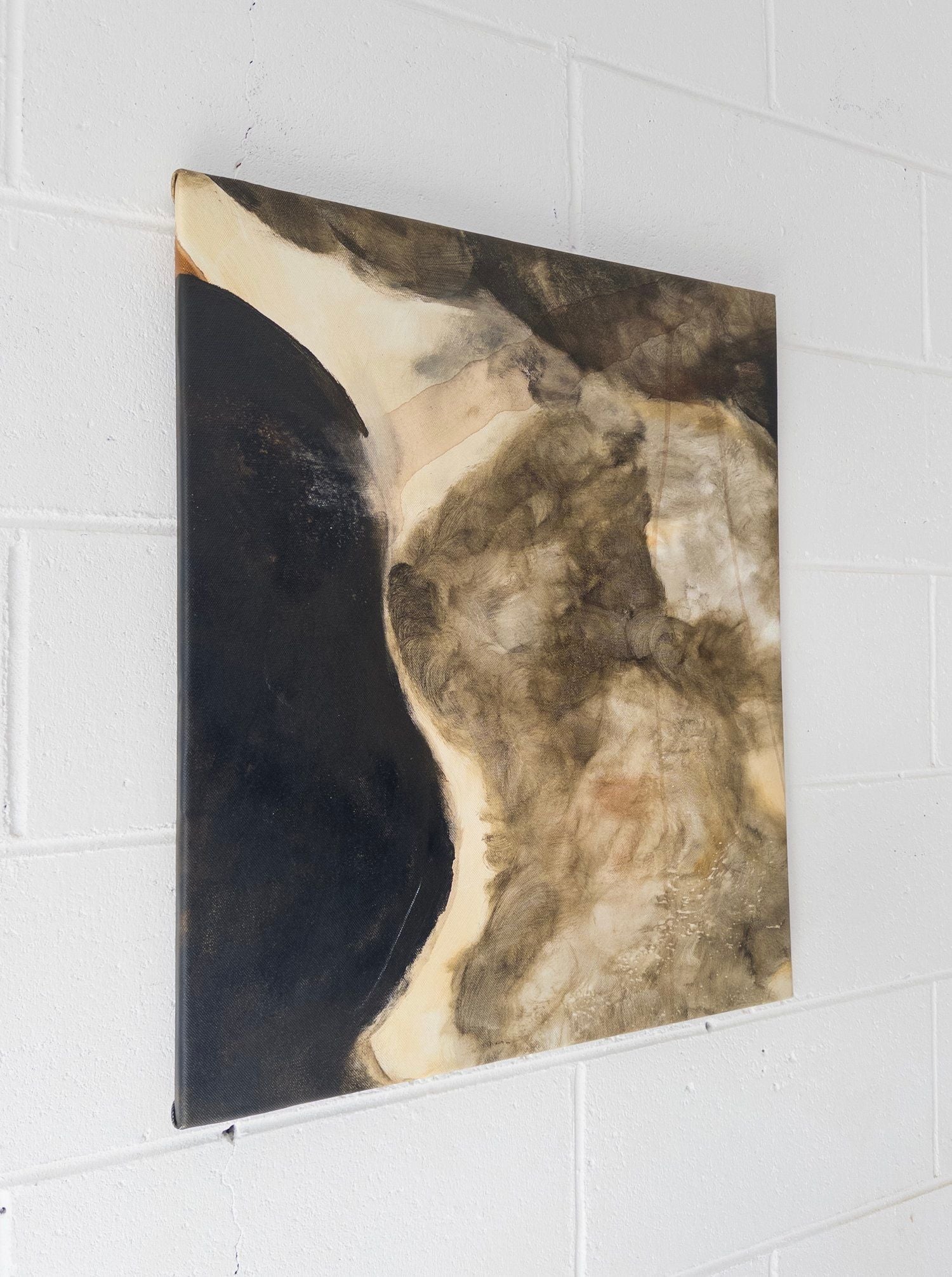 'Nightfall Over Olympia' Mixed Media by Natasha France showcases swirling shapes and earthy tones—black, brown, and beige—on canvas, displayed against a white brick wall.