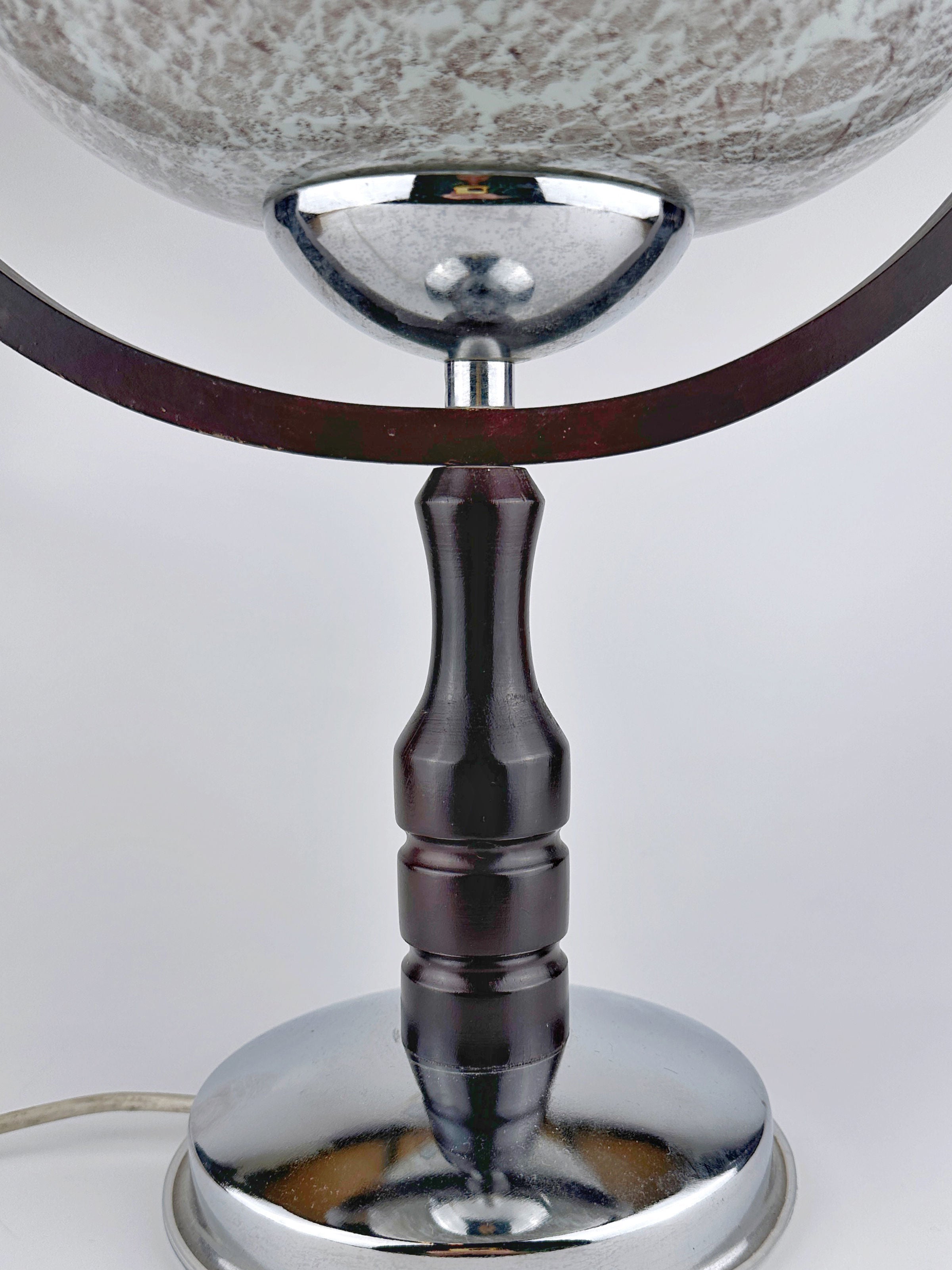 A close-up of the 1960s Sputnik Age Table Lamp by Dodo Vintage shows its shiny chrome and dark wood base with a visible power cord, set against a plain white background.