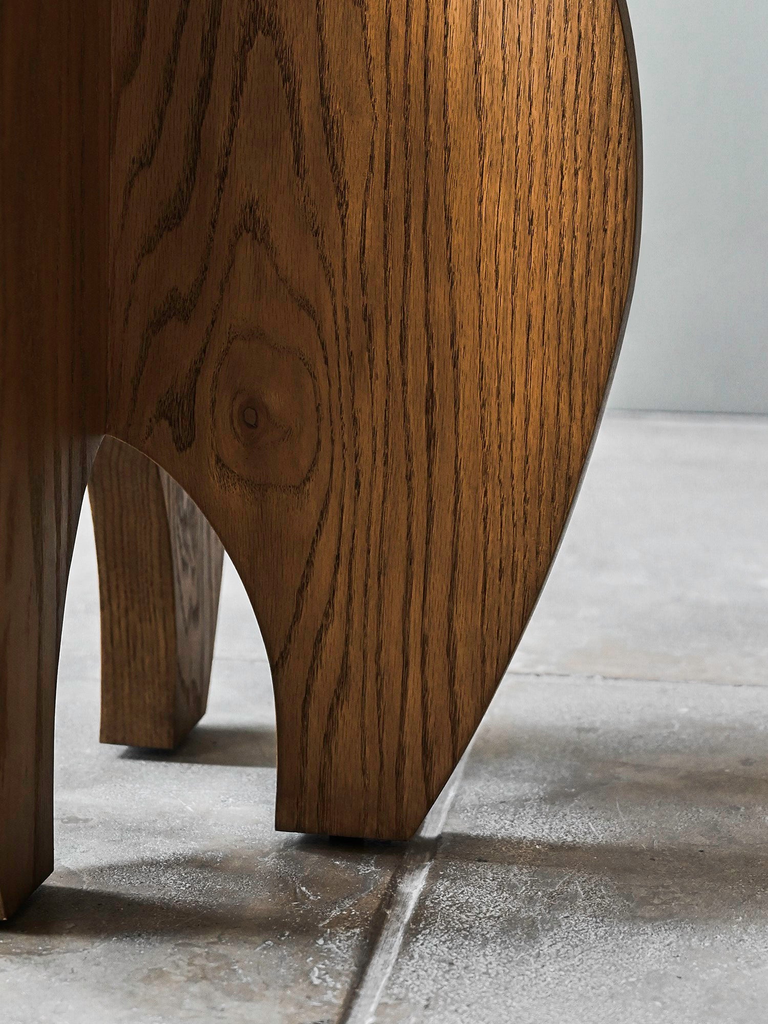 Close-up of the 'Fusée' Stained Oak Side Table by Studio OSKLO, featuring a natural wood grain finish and playful elephant-inspired design with four sturdy legs—ideal as a whimsical accent for your space.
