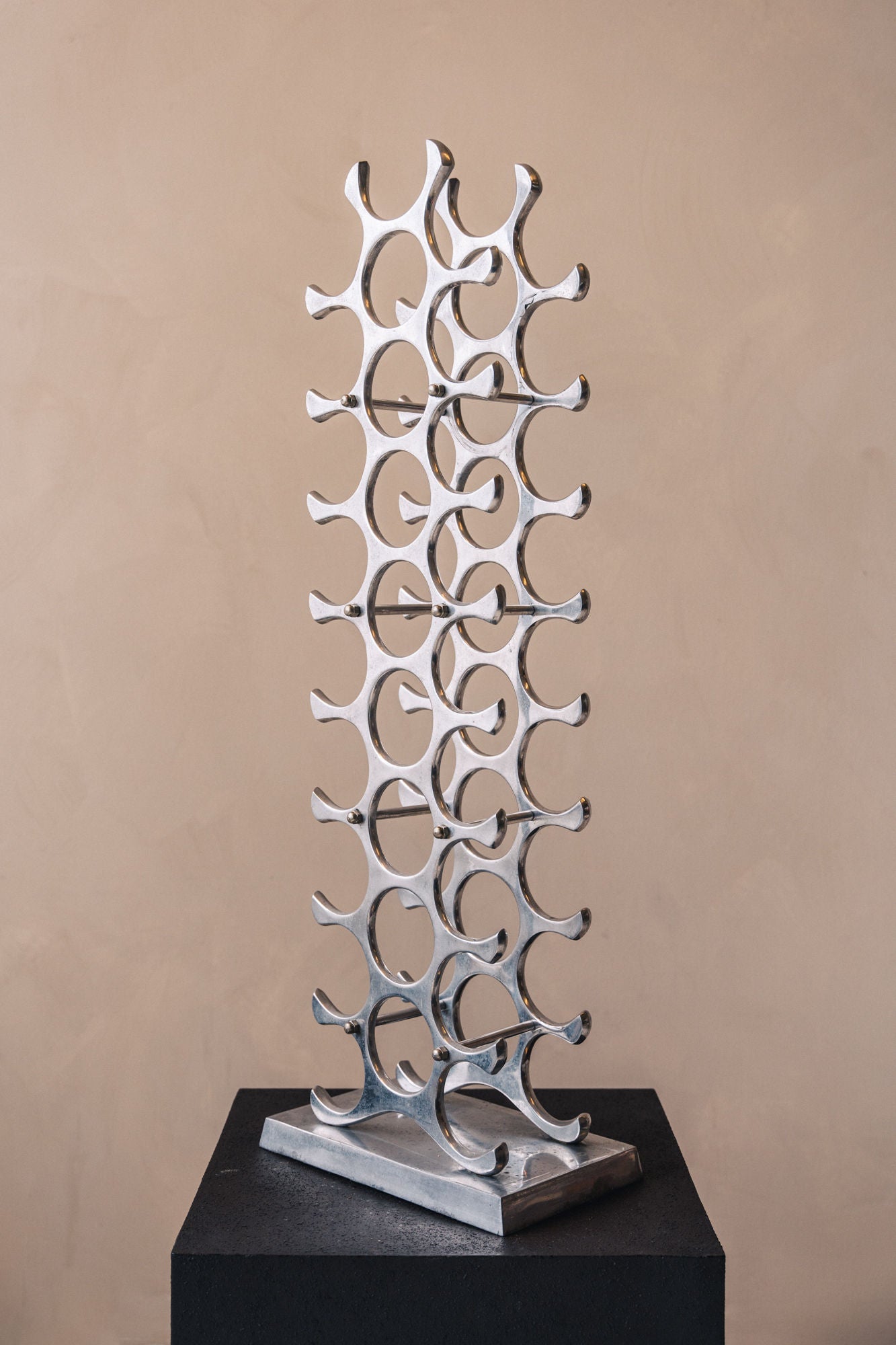Polished aluminum wine rack tower with curved bottle holders