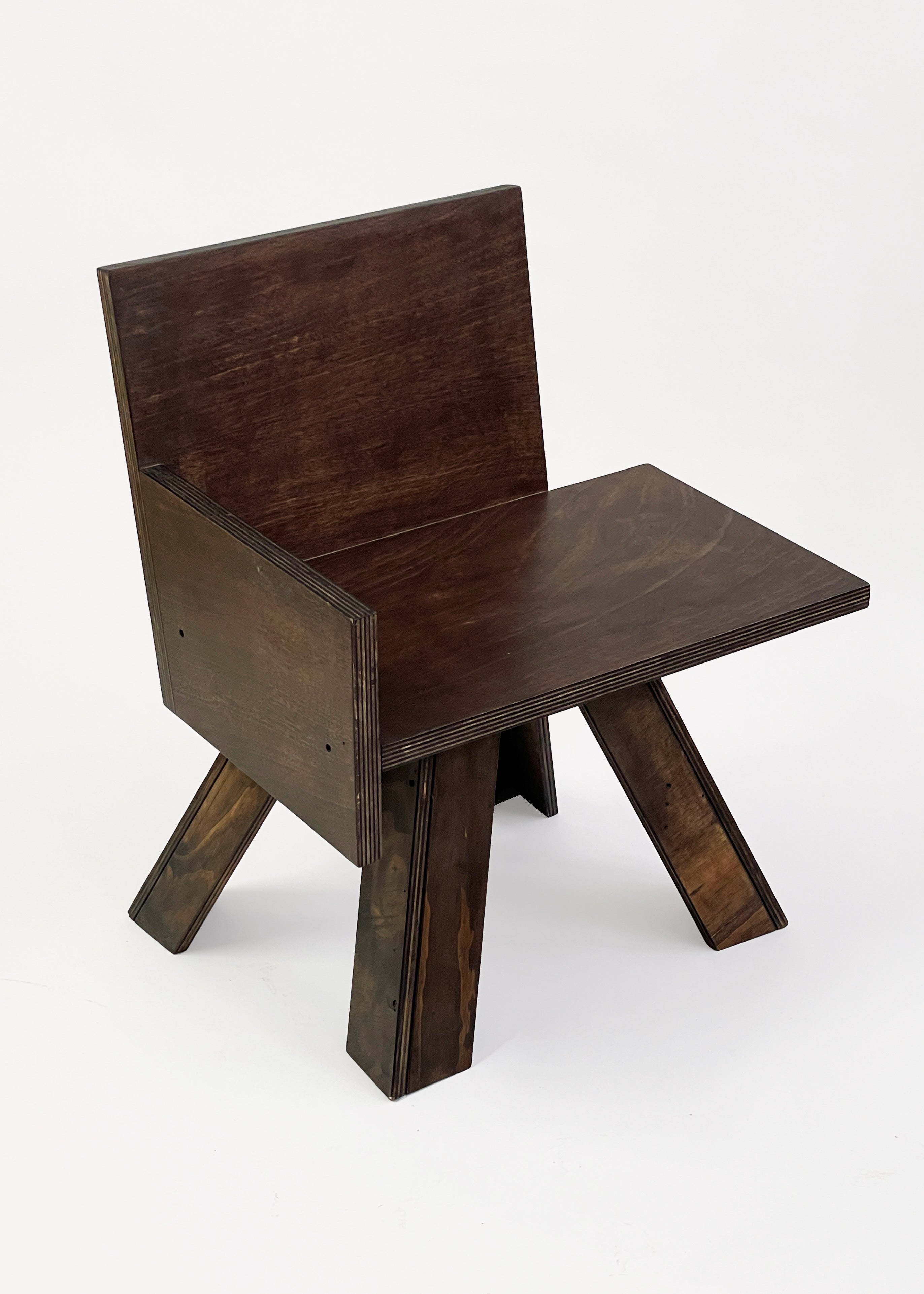 The End Table Chair by GOONS is a modern dark wood chair with a flat backrest, wide seat, and angled legs in clean geometric lines—artisanal design inspired by Paris studios—set against a plain white background.