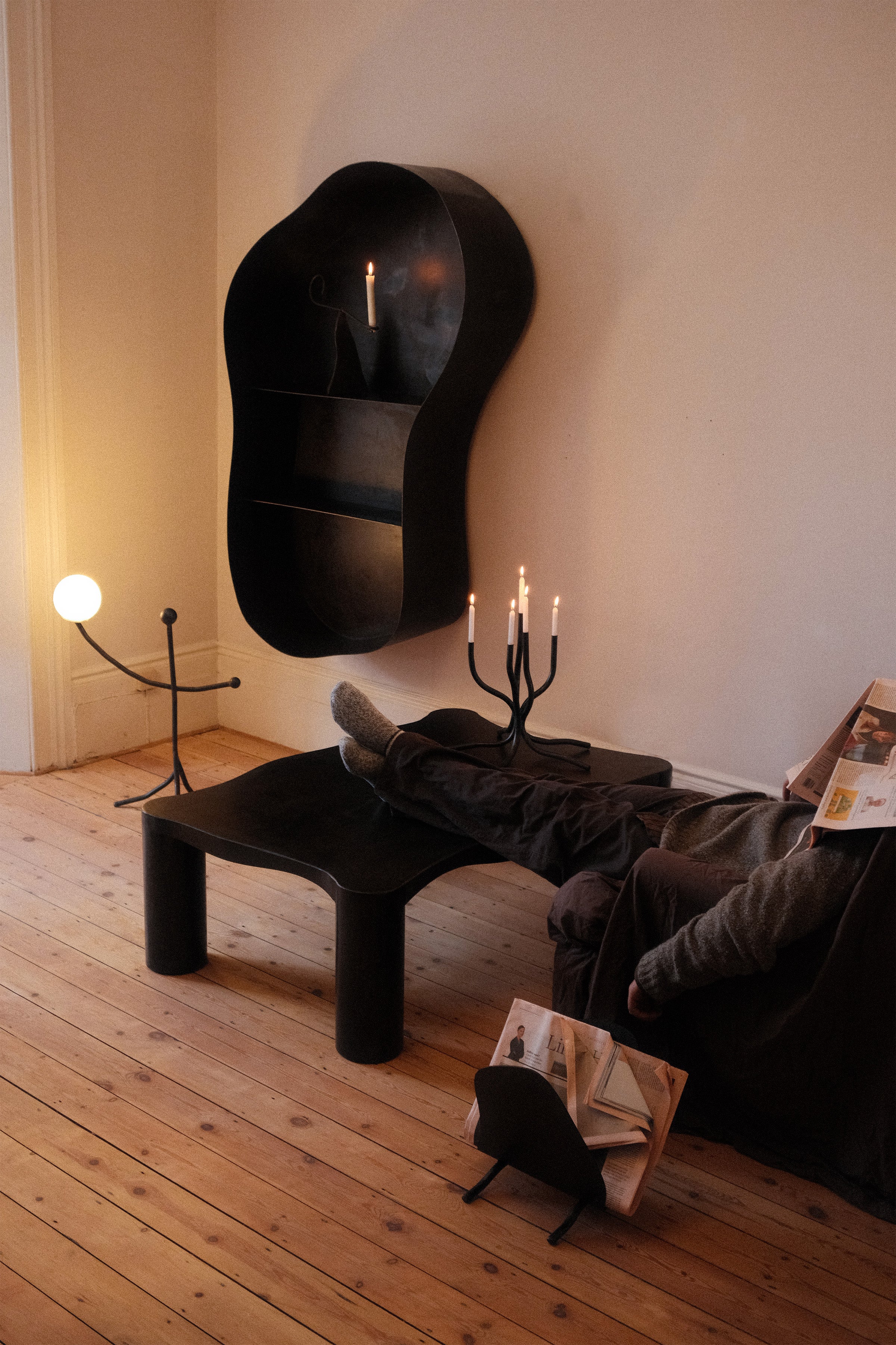 Modern black table lamp with spherical base in minimalist bedroom setting