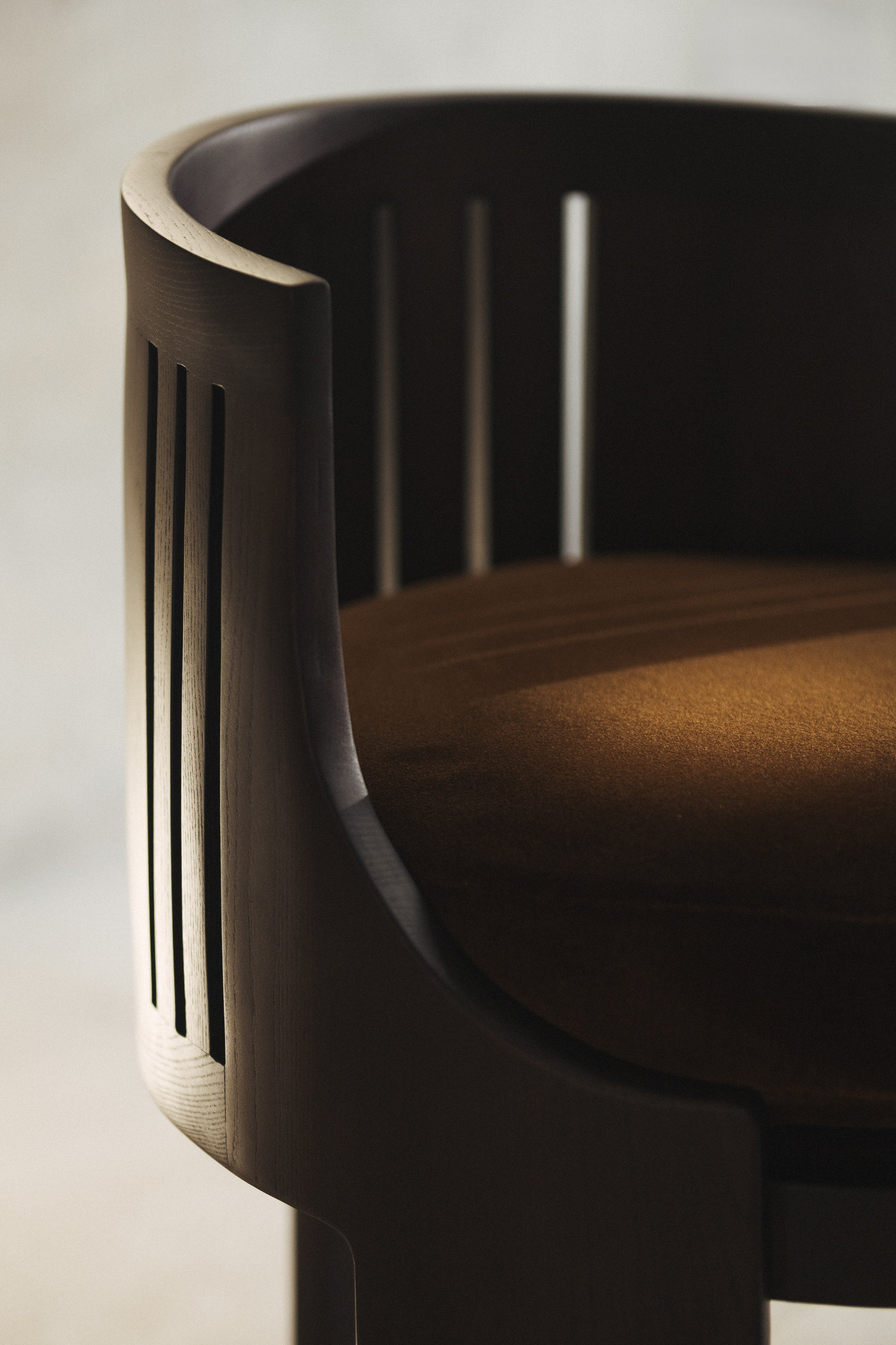 La Chaise 01 — close-up of wooden frame with brown upholstery