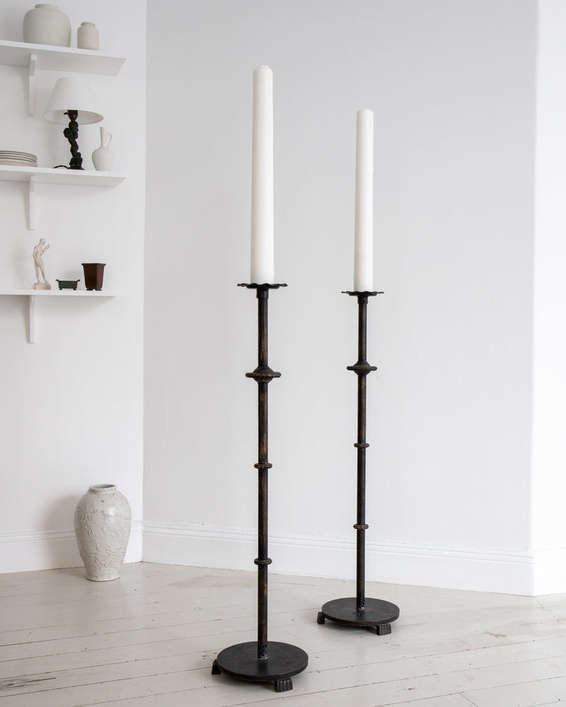 Pair of Monumental Cast Iron Floor Candleholders by Böhlmarks, Sweden, 1930s — close-up of candleholders against white wall
