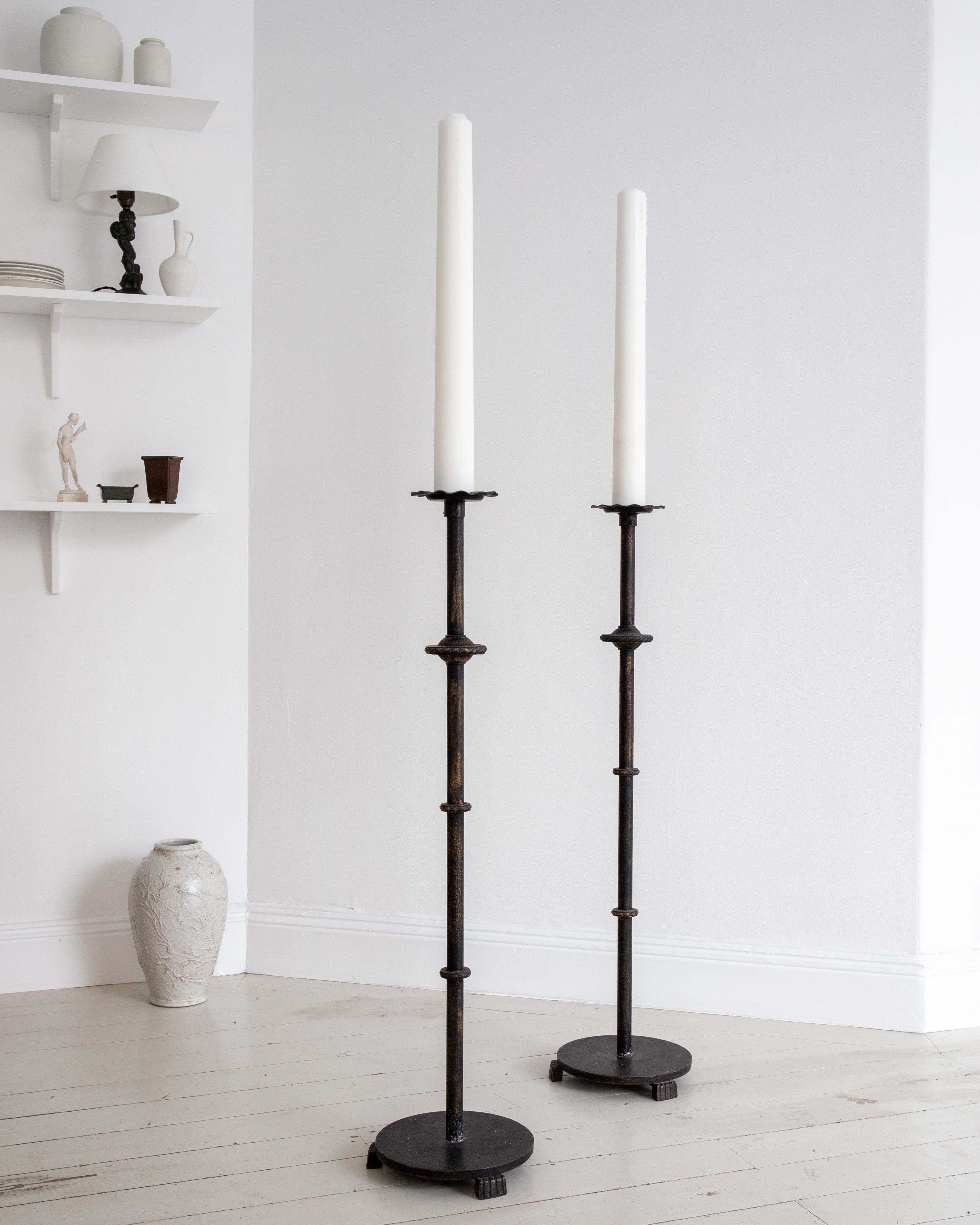 Pair of Monumental Cast Iron Floor Candleholders by Böhlmarks, Sweden, 1930s — close-up of candleholders against white wall