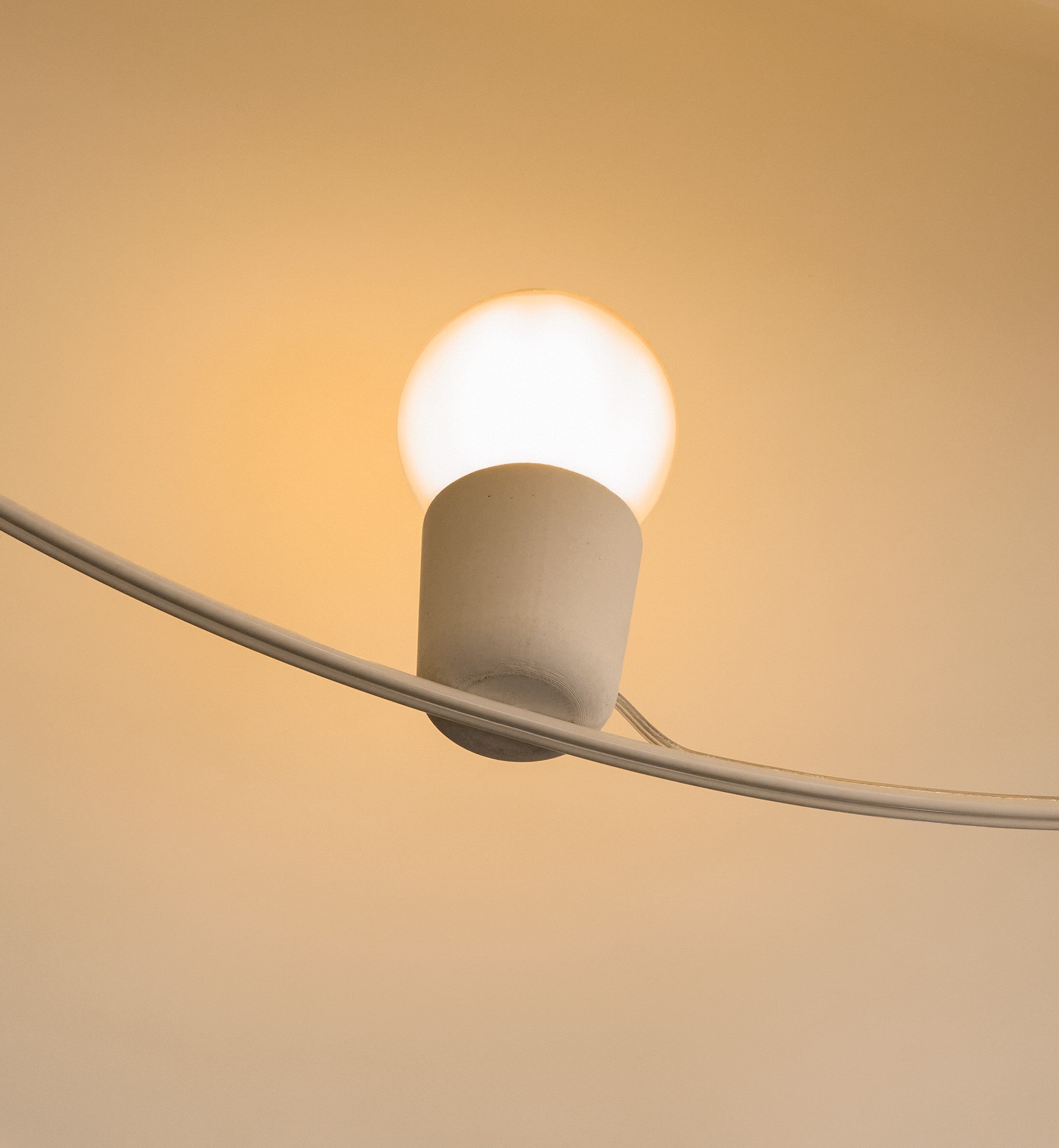 Reminder 002 – Pearl – Ceiling Light — close-up of white fixture against warm wall