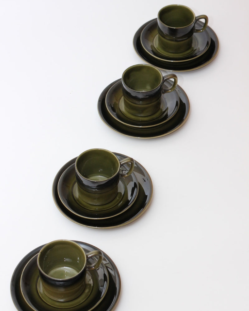 Set of Four Ceramic Cups — top view of green and black cups on plates