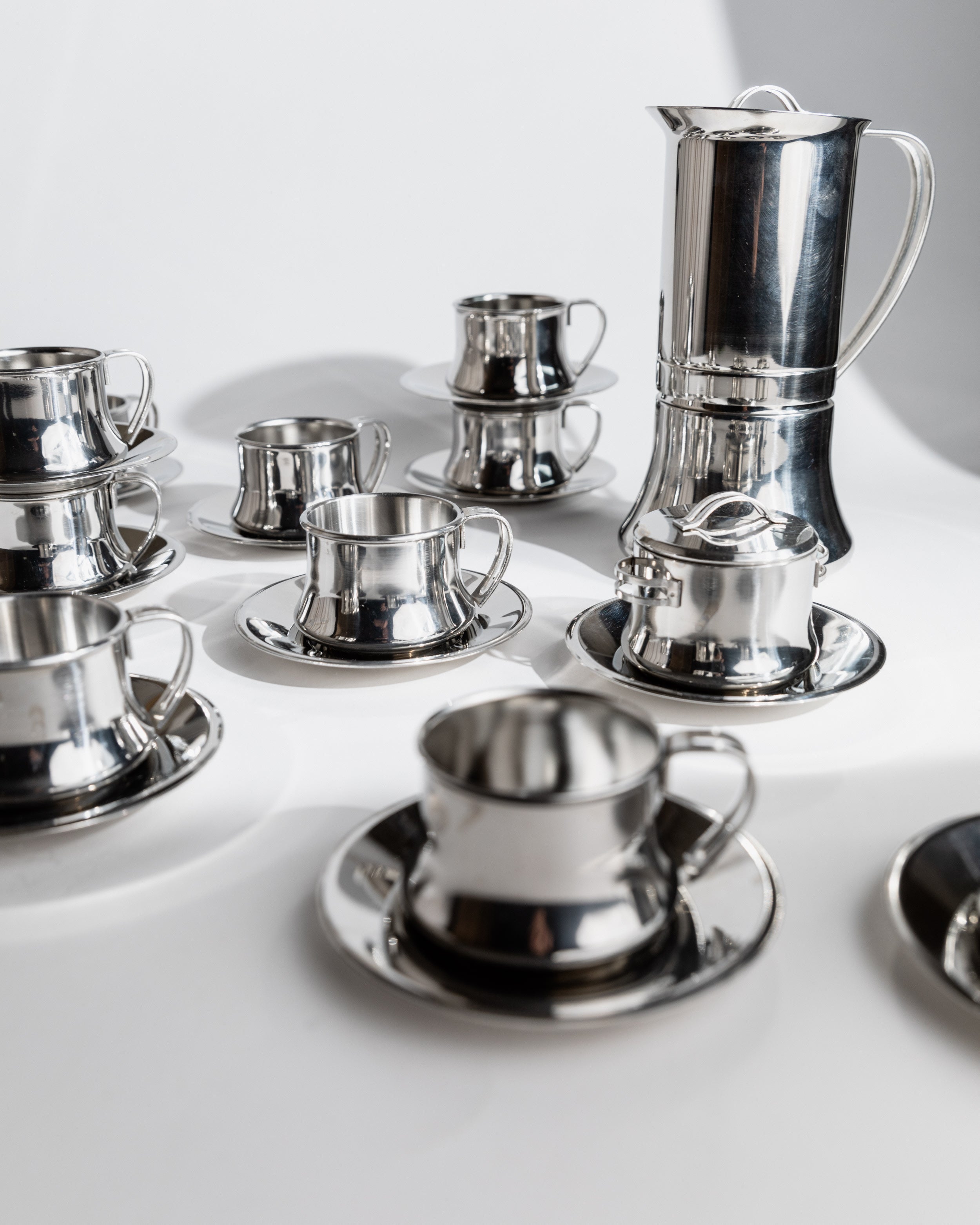 Polished stainless steel coffee set with cups and tall pot