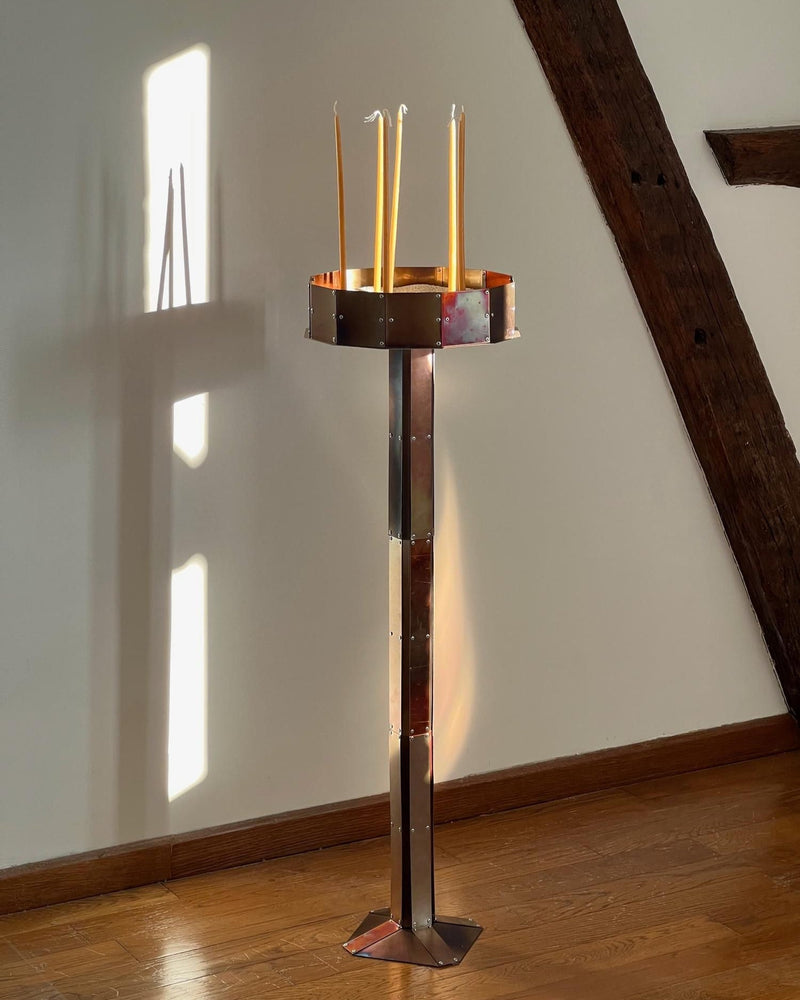 Modern copper candleholder with tall stand holding four tapered candles