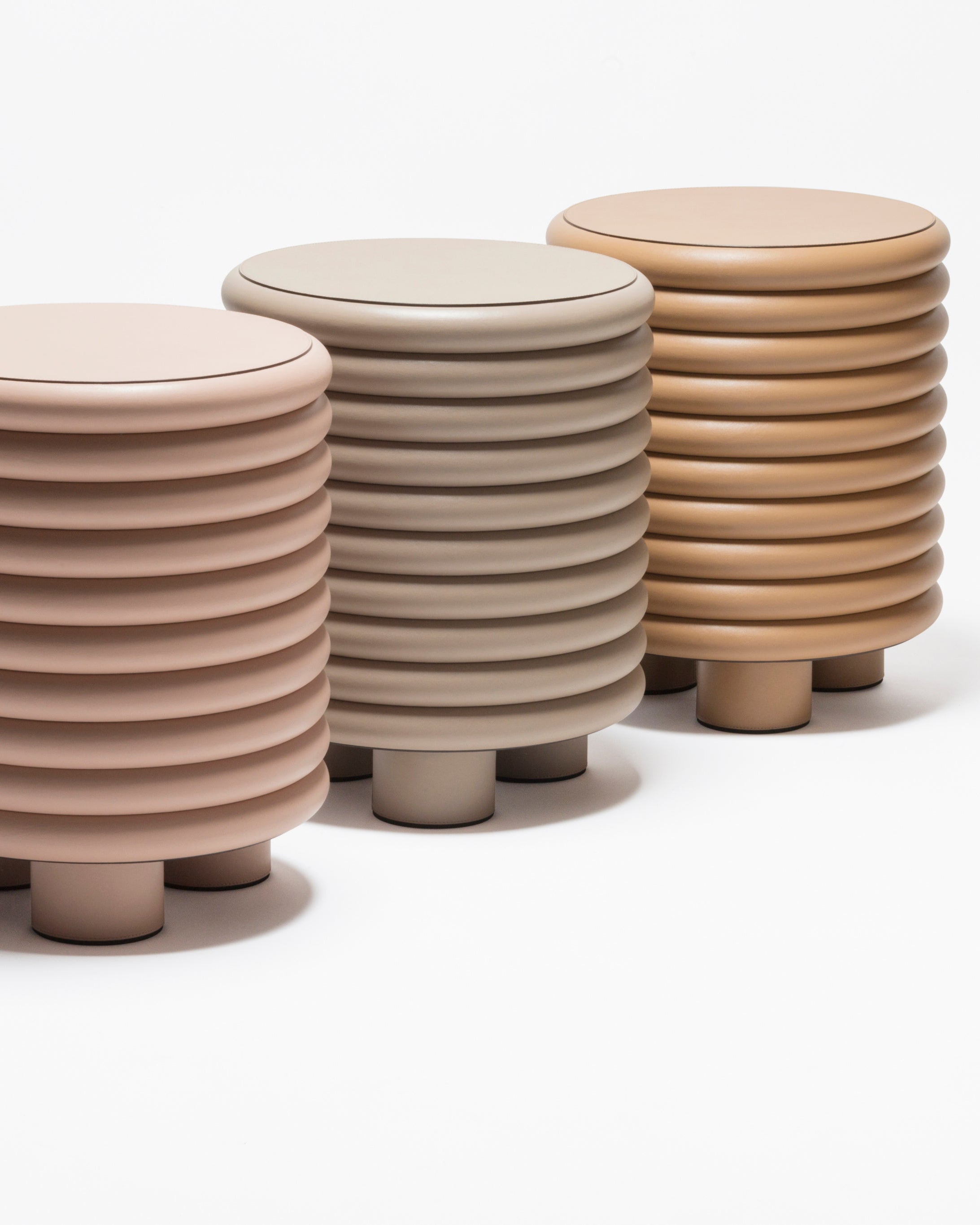 Three Scala leather stools in pink, taupe and caramel tones