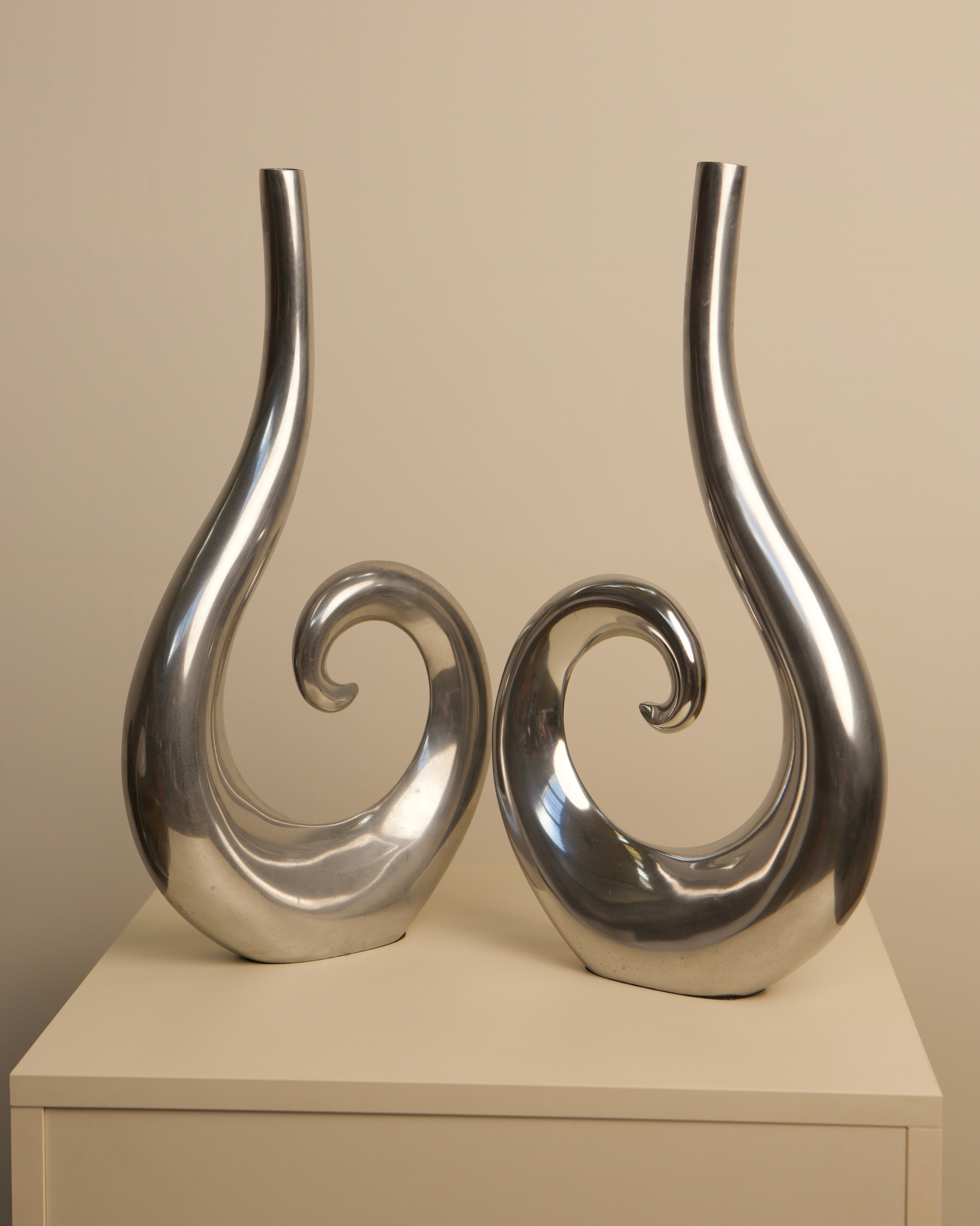 Pair of sleek Italian aluminum vases with curved spiral design 1980s