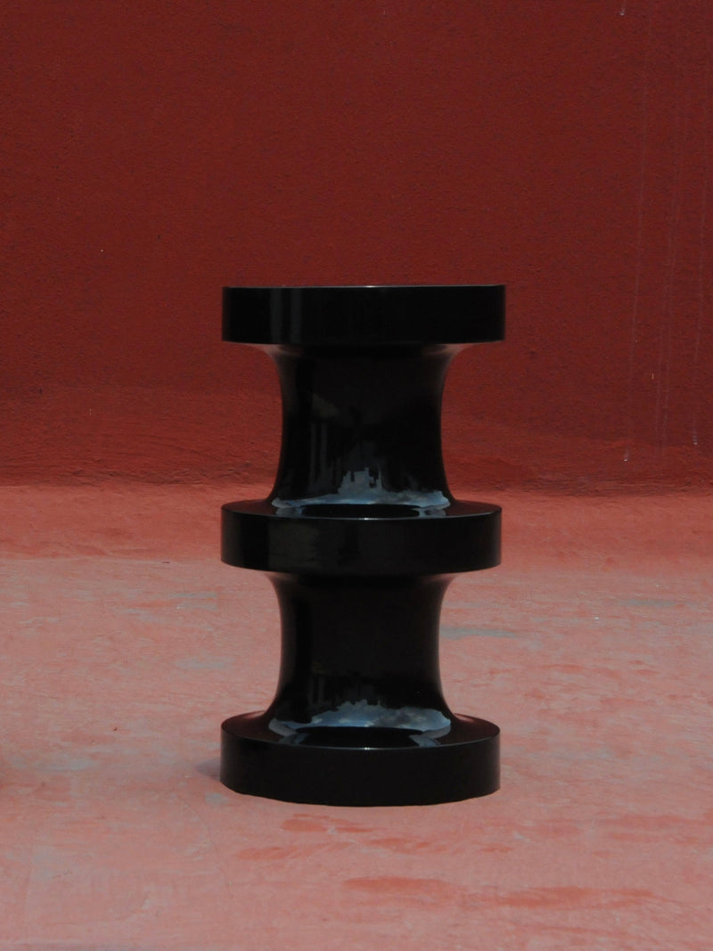 Chess' Stool concave in lacquer wood — front view against red background