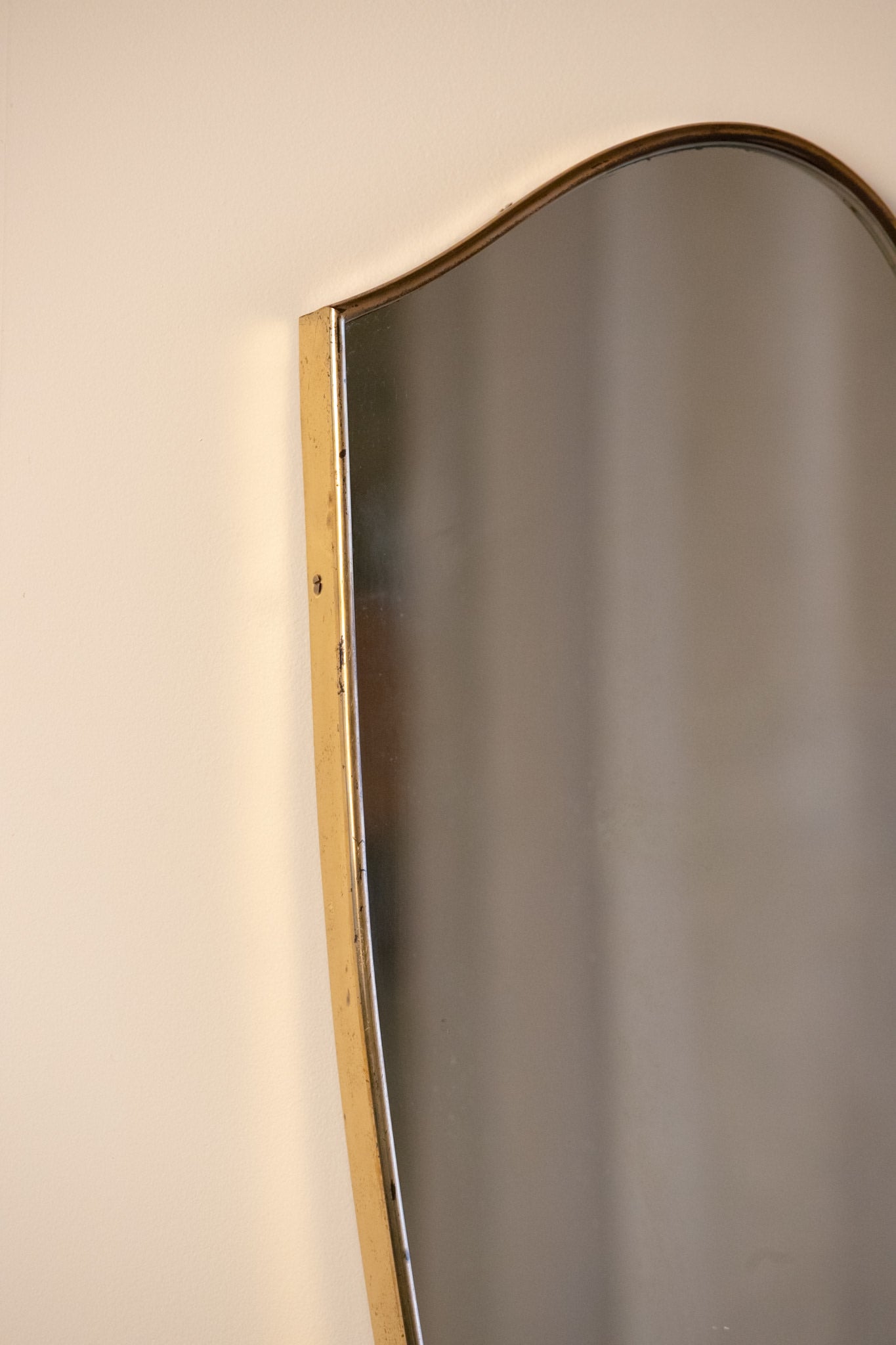 Large Midcentury Italian Brass Shield Mirror — side angle showing brass frame detail