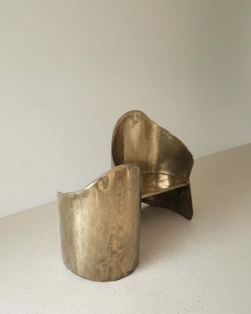 Curved brass loveseat detail showing sculptural metalwork