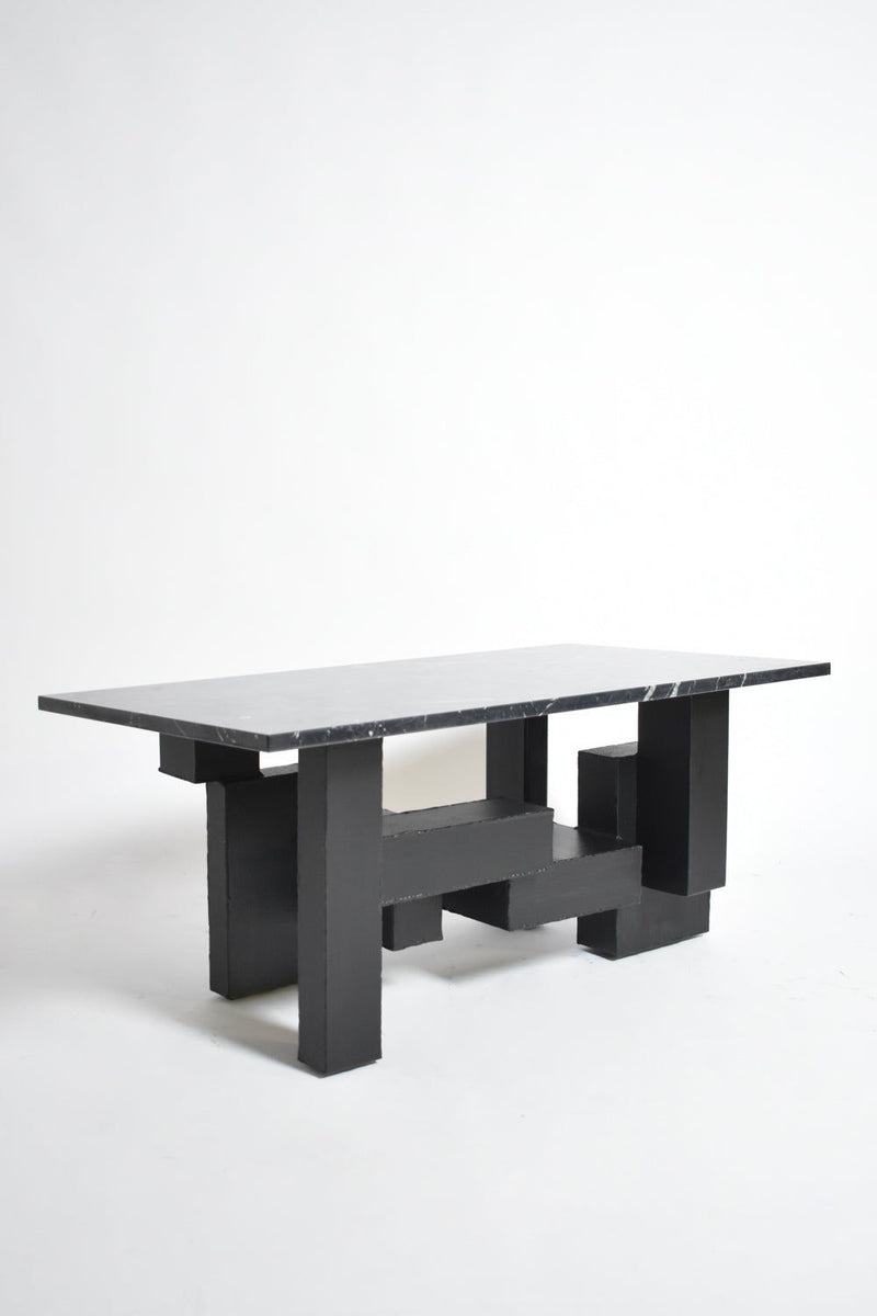 The Cubist Iron and Marble Coffee Table by Barracuda Interiors (1980s) features a thick black marble top and geometric iron legs, showcased against a plain white background.