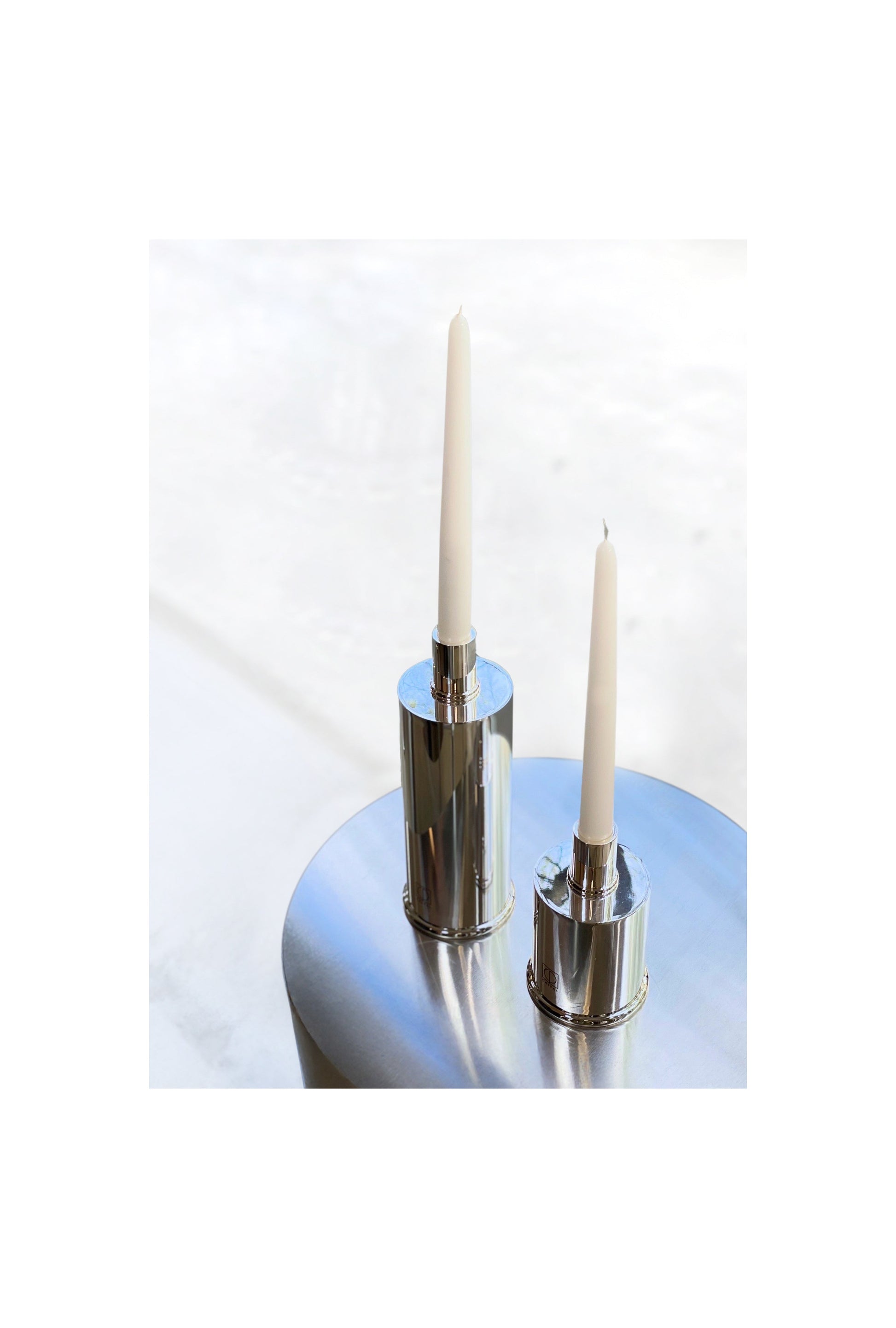 Silver Plated Candle Holders in Brass and Silver Plated Brass — close-up on polished silver surface with candles