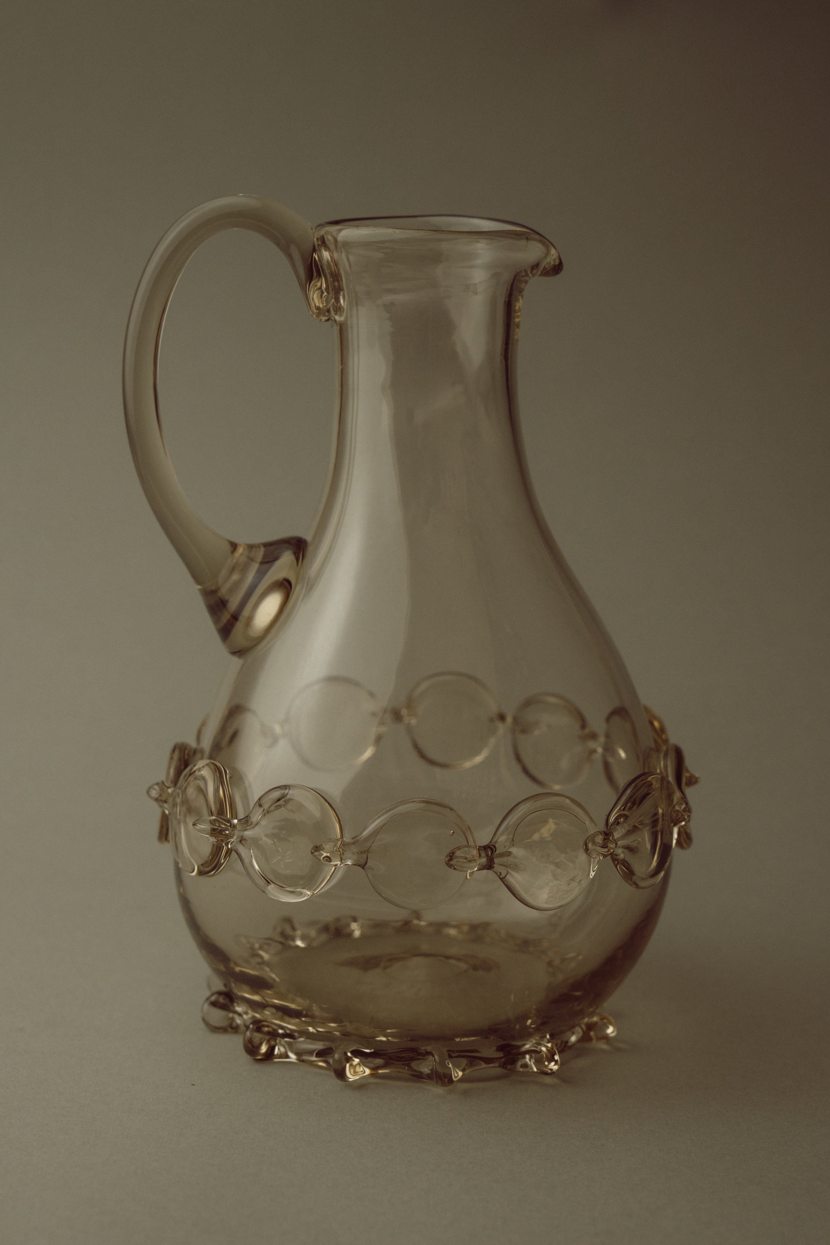 Contemporary Carafes in Glass with ornaments - Mouthblown Collection — close-up of glass carafe with decorative orbs