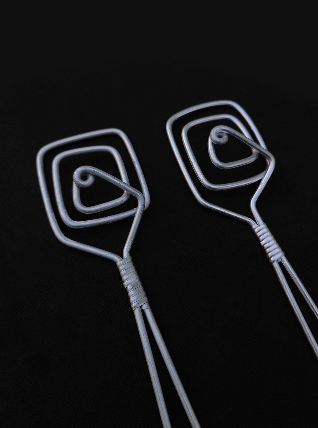 80's Salad Servers — close-up of twisted metal design on black background