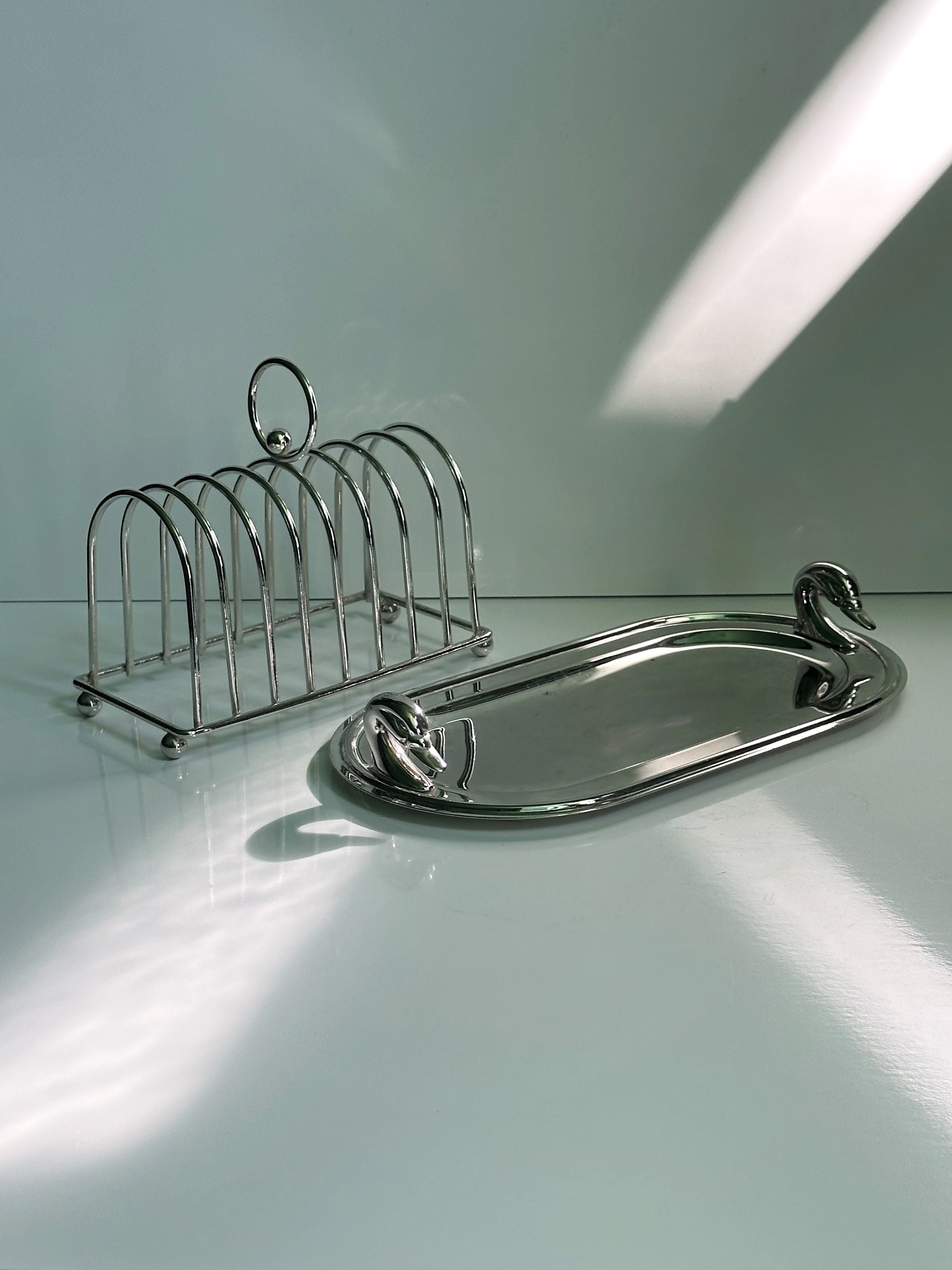 Silver-plated oval tray with swan handles and arched toast rack