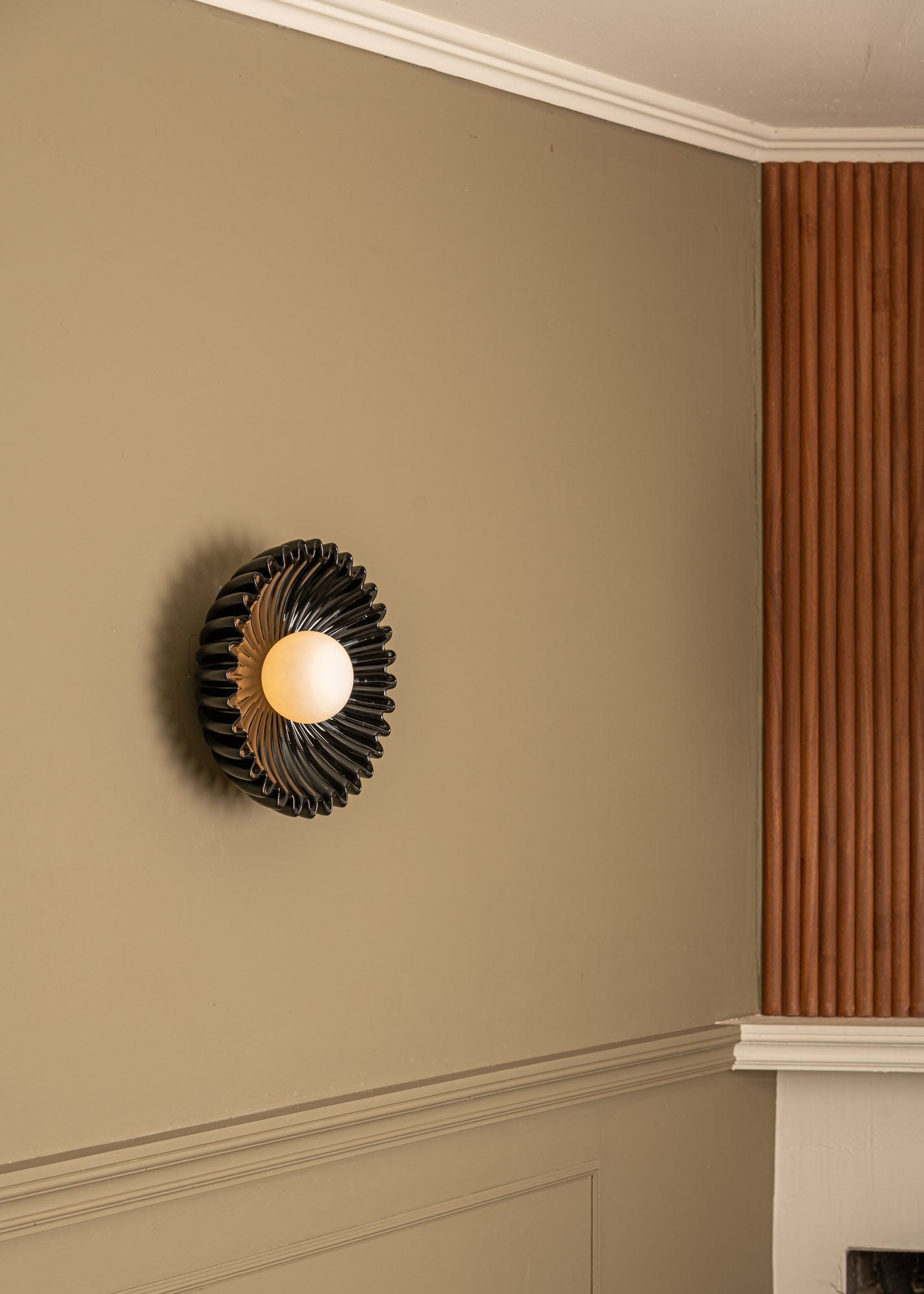Ostro black ceramic wall light with radiating sculptural design