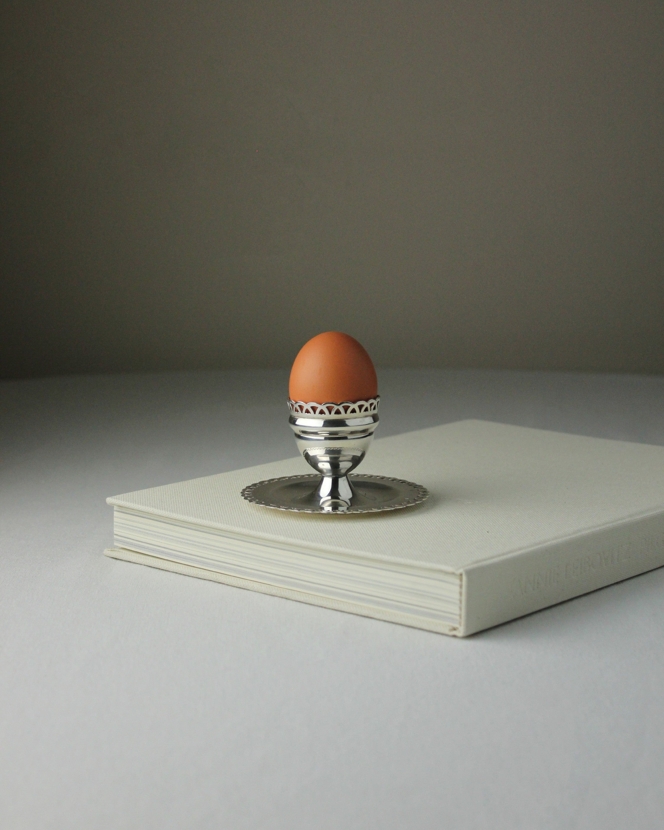 Alpaca Egg Cup — positioned on a light gray book with an egg