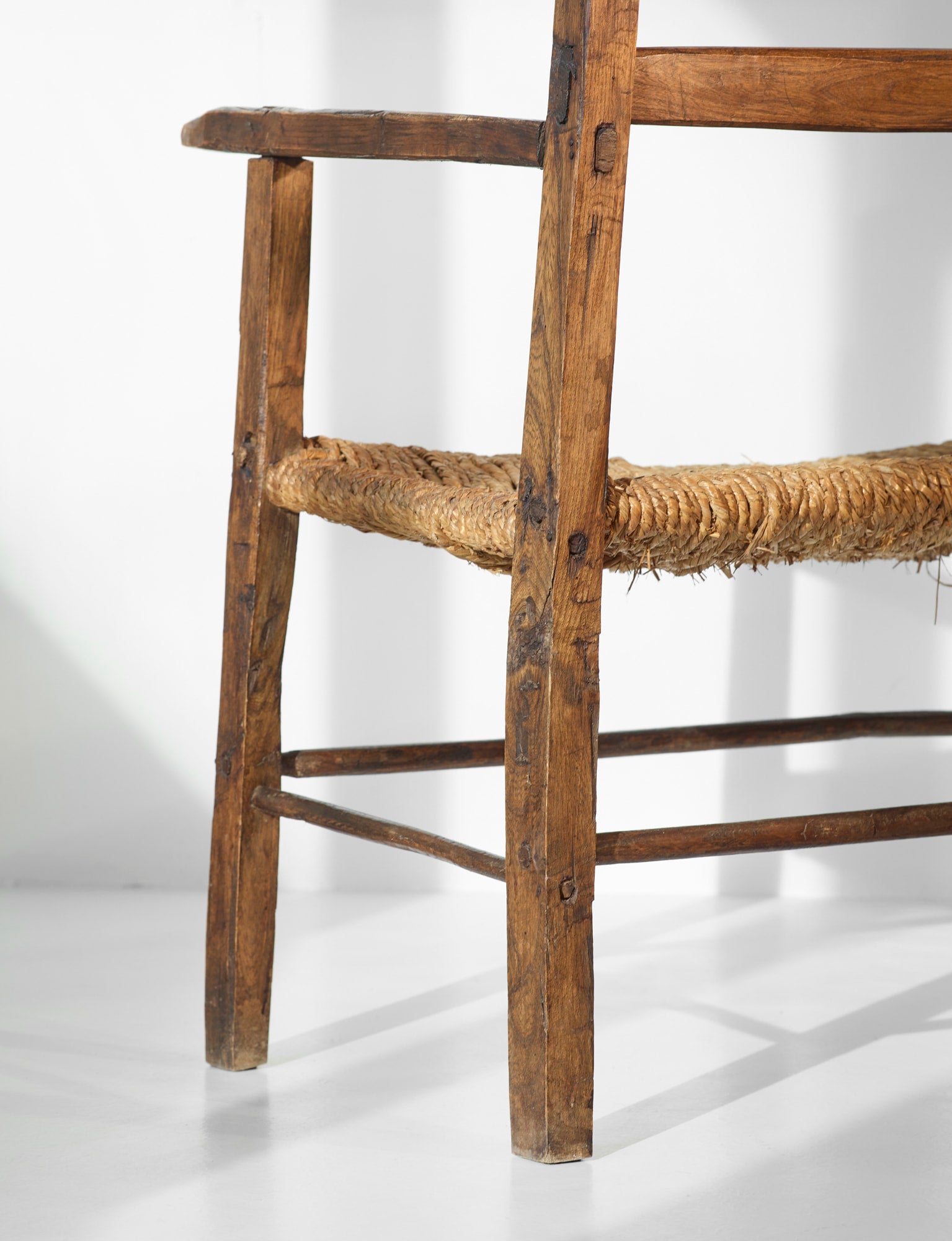 A French folk bench from the 19th Century. Wood and straw — close-up