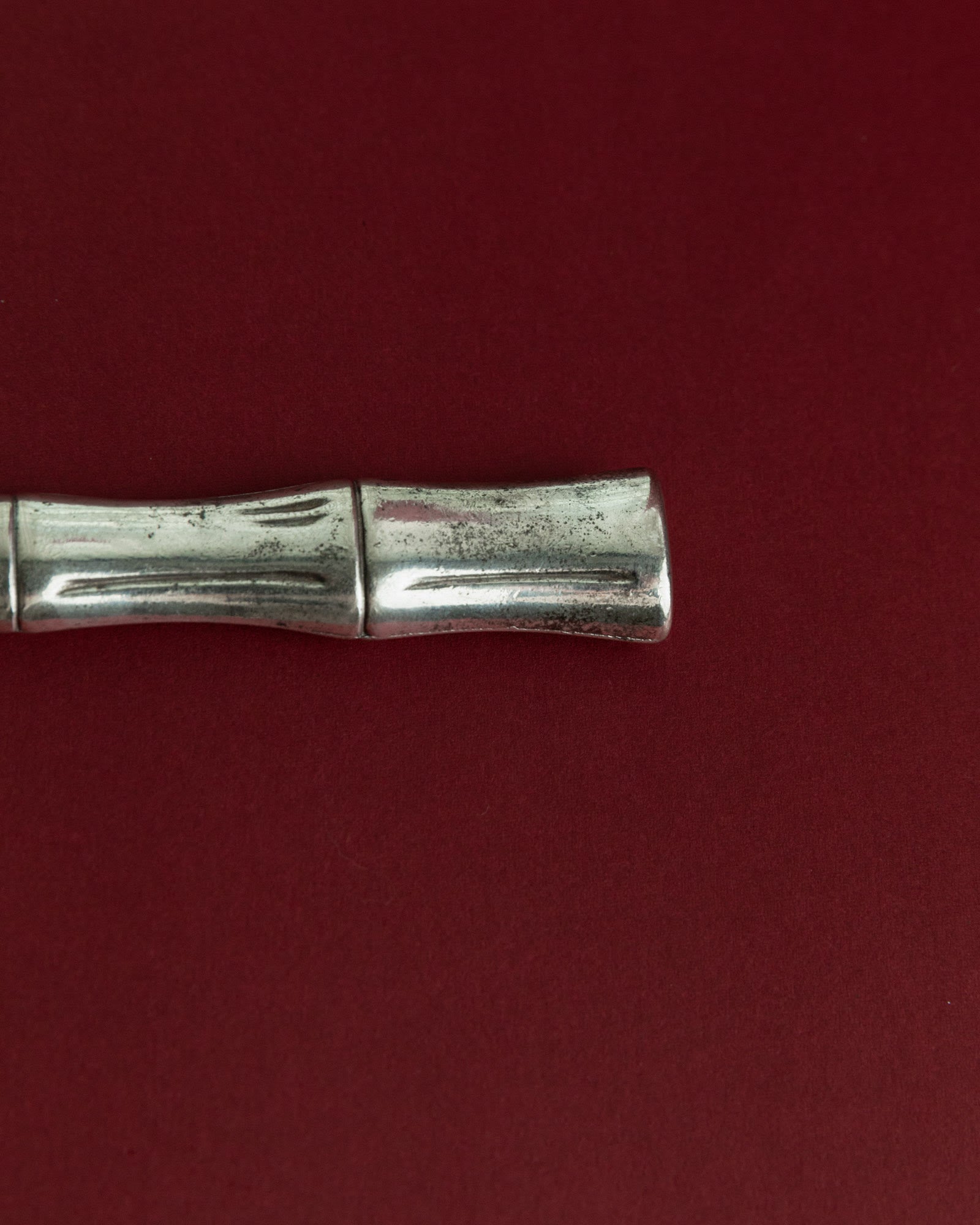 Vintage 1970s Silver Plated Bottle Opener, Bamboo Design — top view on red background