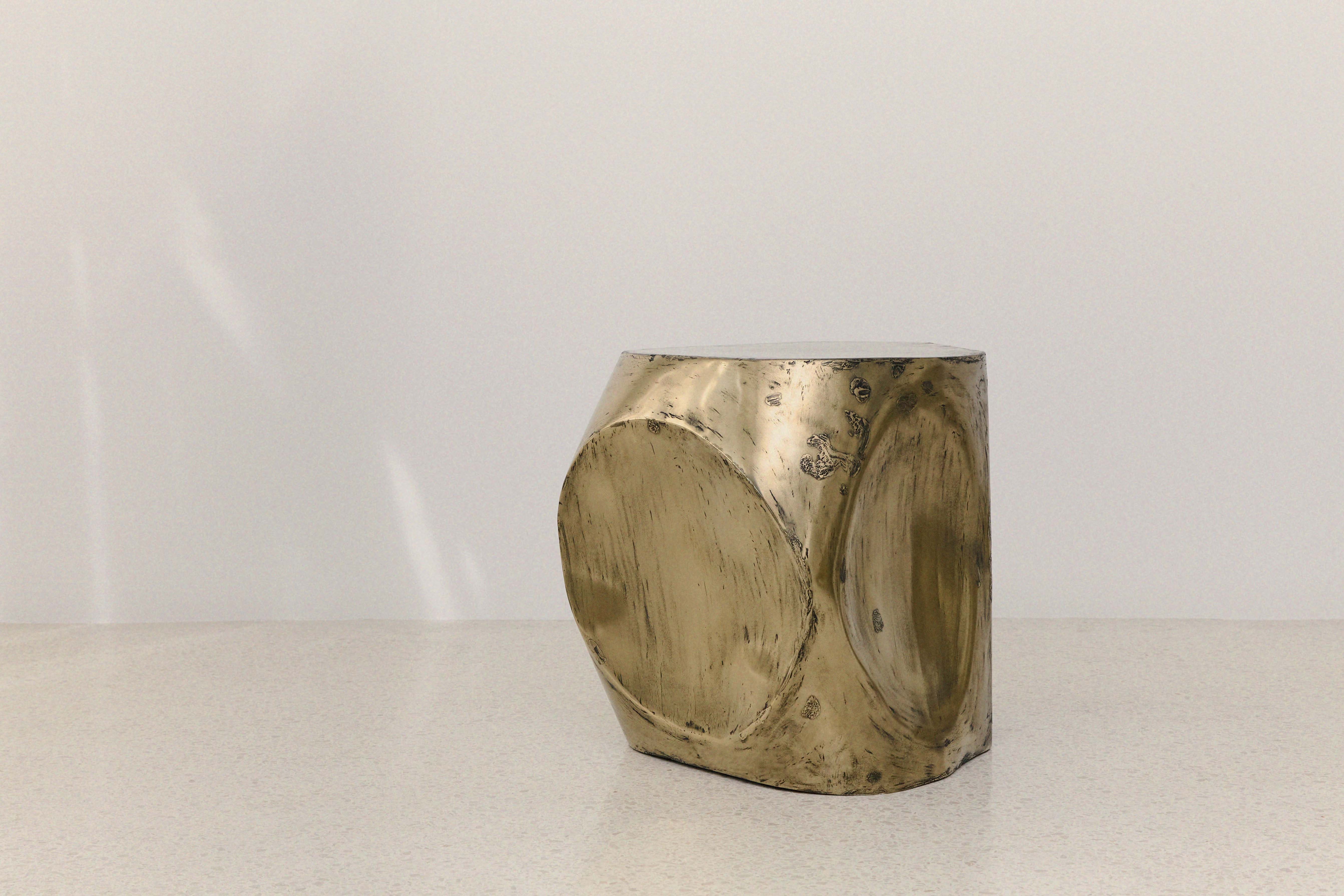 ROCHER SMALL TABLE IN POLISHED BRASS RESIN — side angle on white surface