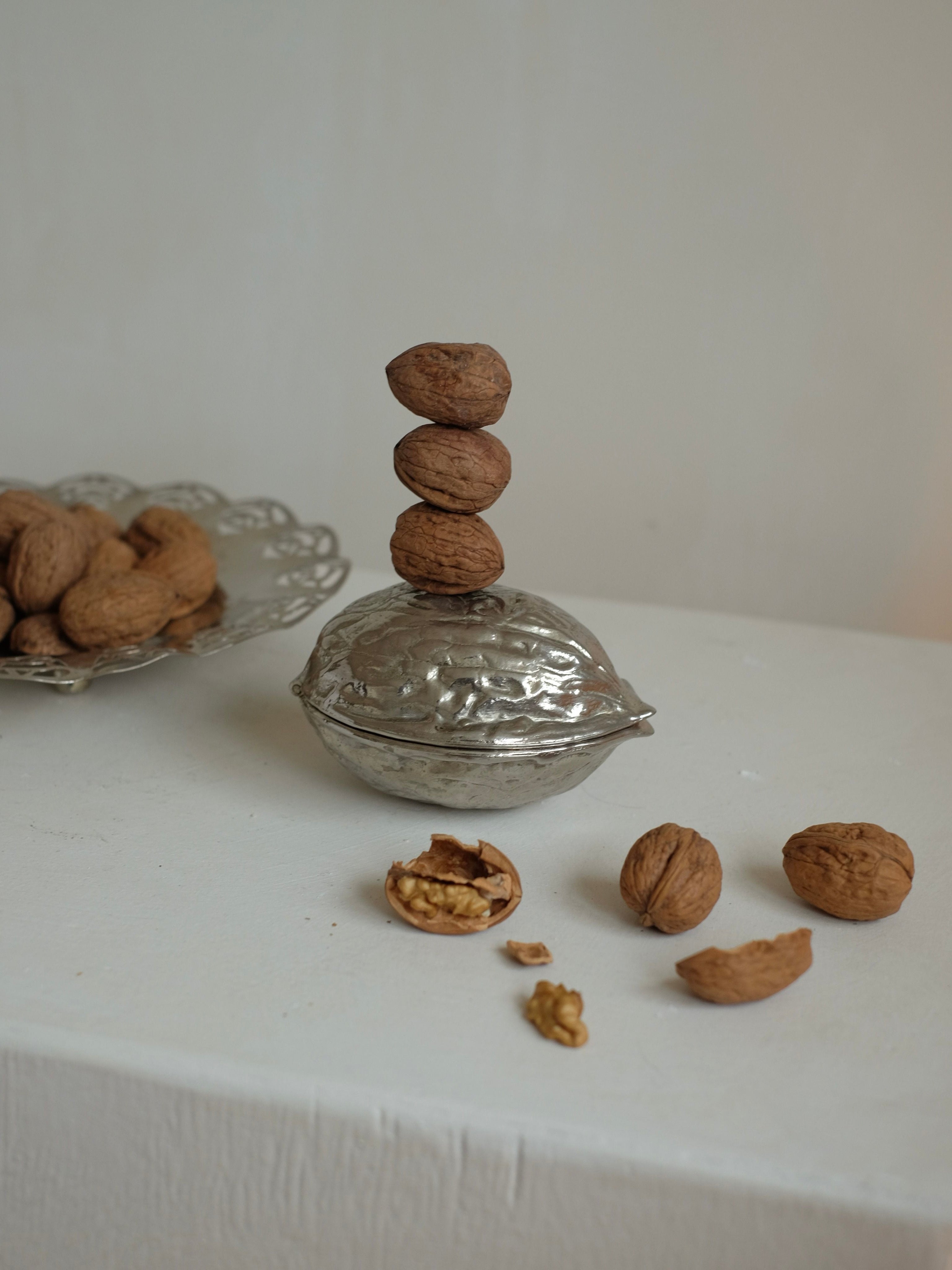Nutcracker — close-up of polished silver with stacked walnuts