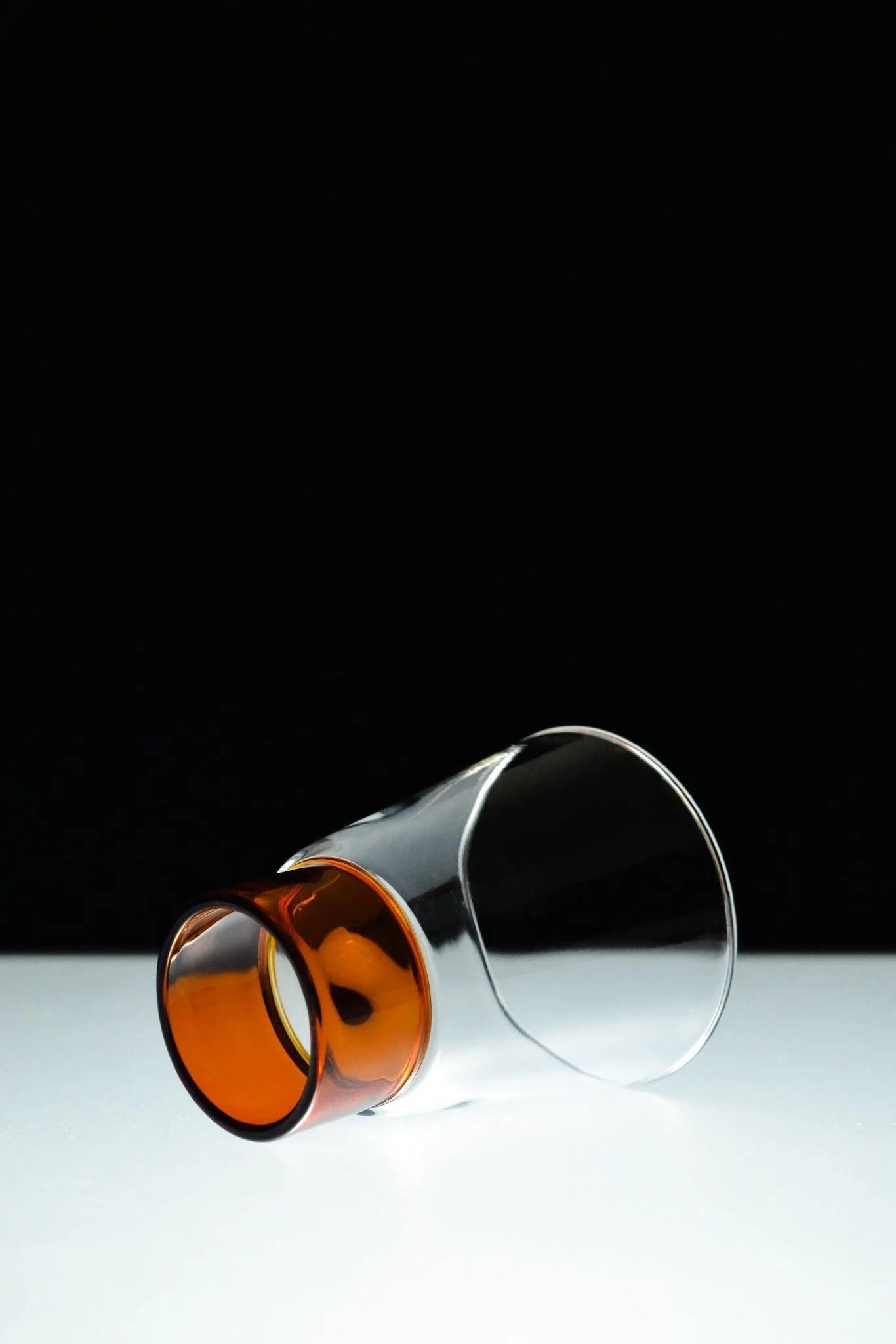 Podio' Glass - Amber — side angle showing amber base and clear body