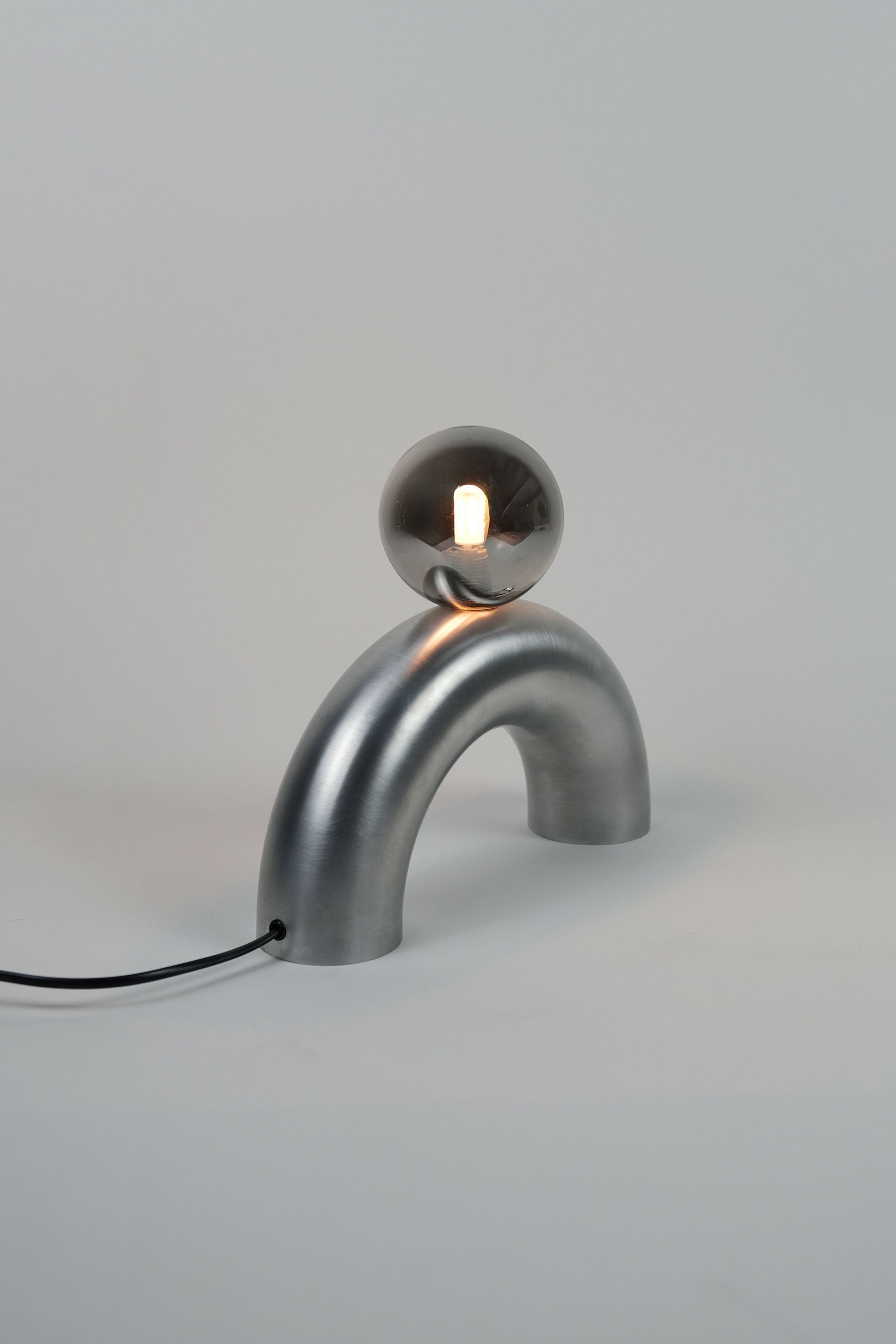 Aluminum arc table lamp with spherical glass shade detail view