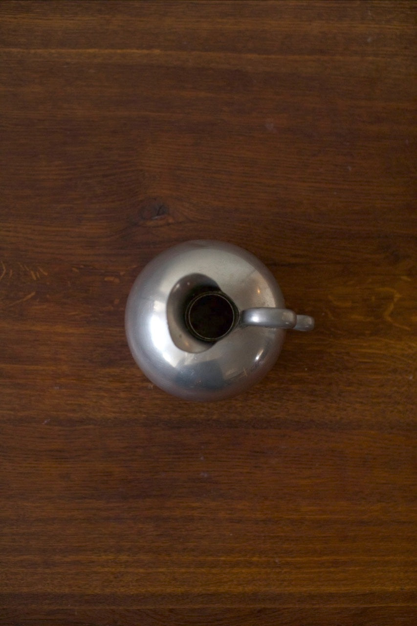 Tin Vase — top view of shiny tin surface on wooden table