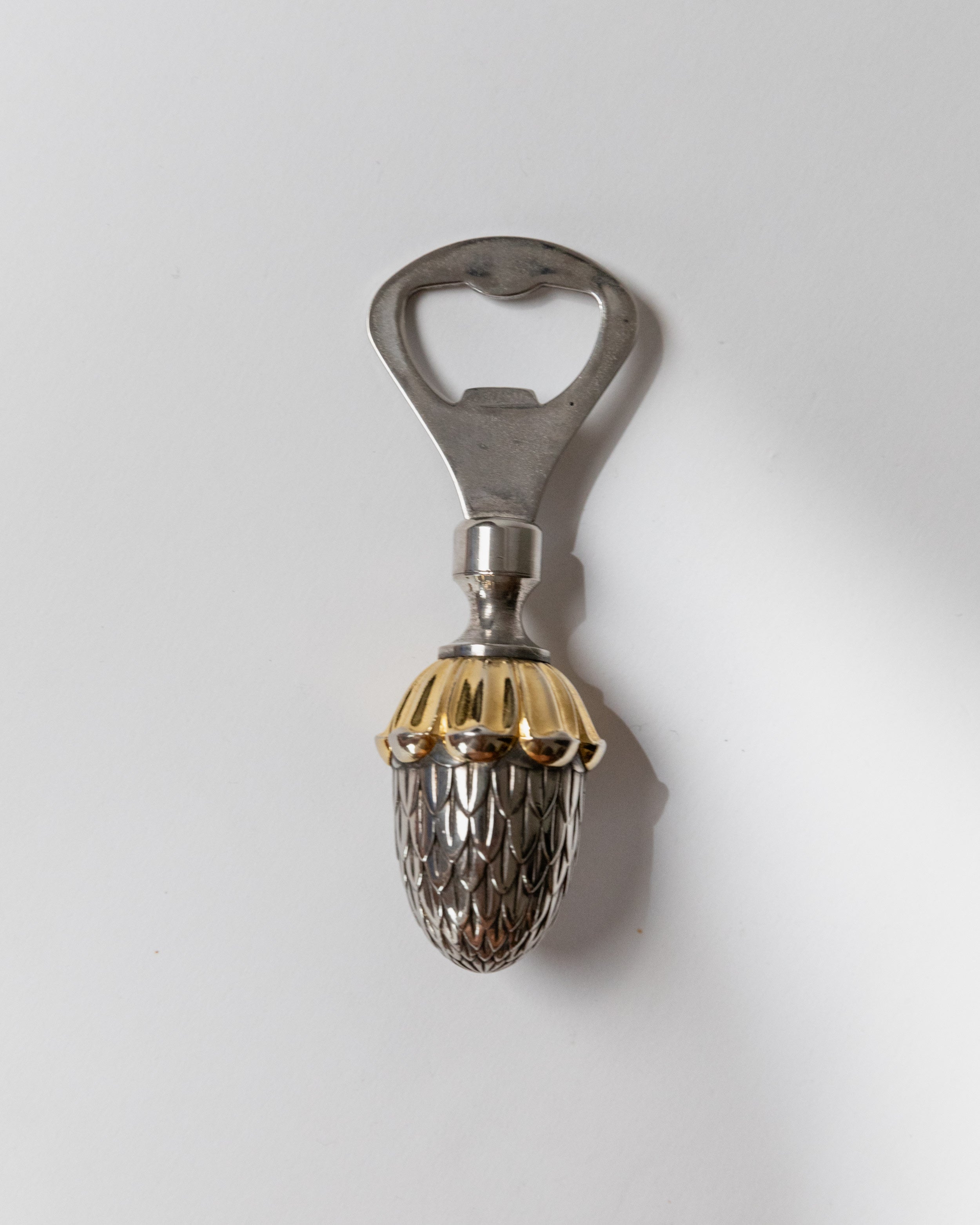 Silver plated acorn bottle opener with ornate mesh design detail