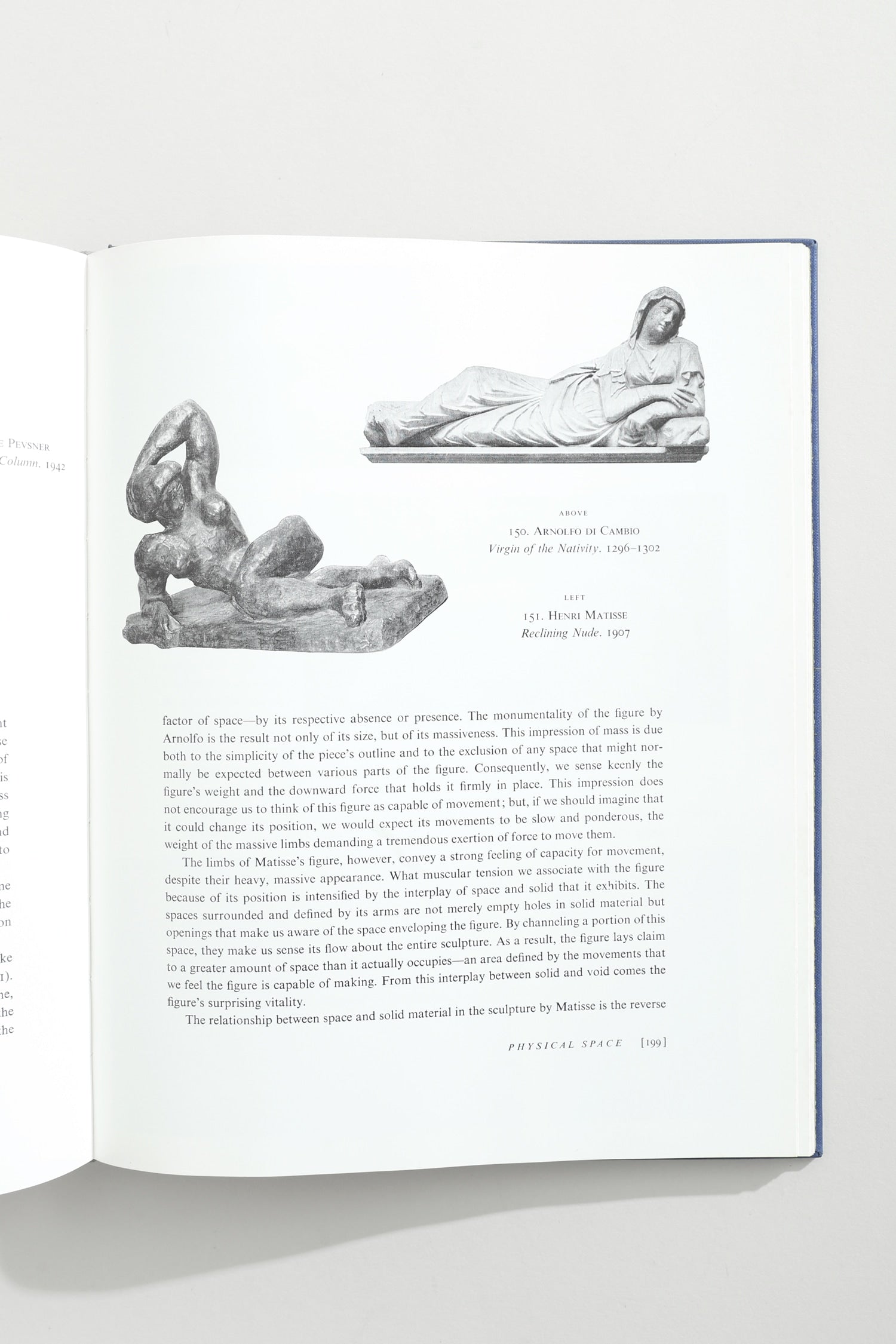 The Visual Experience Book — open on white table with sculptures