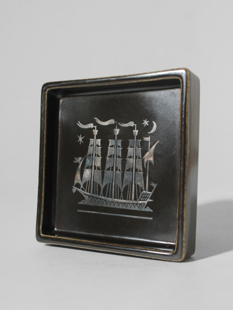 Sven Jonson "Facett" Ceramic Ashtray, For Gustavsberg, 1960s — angled view showing ship design on dark ceramic